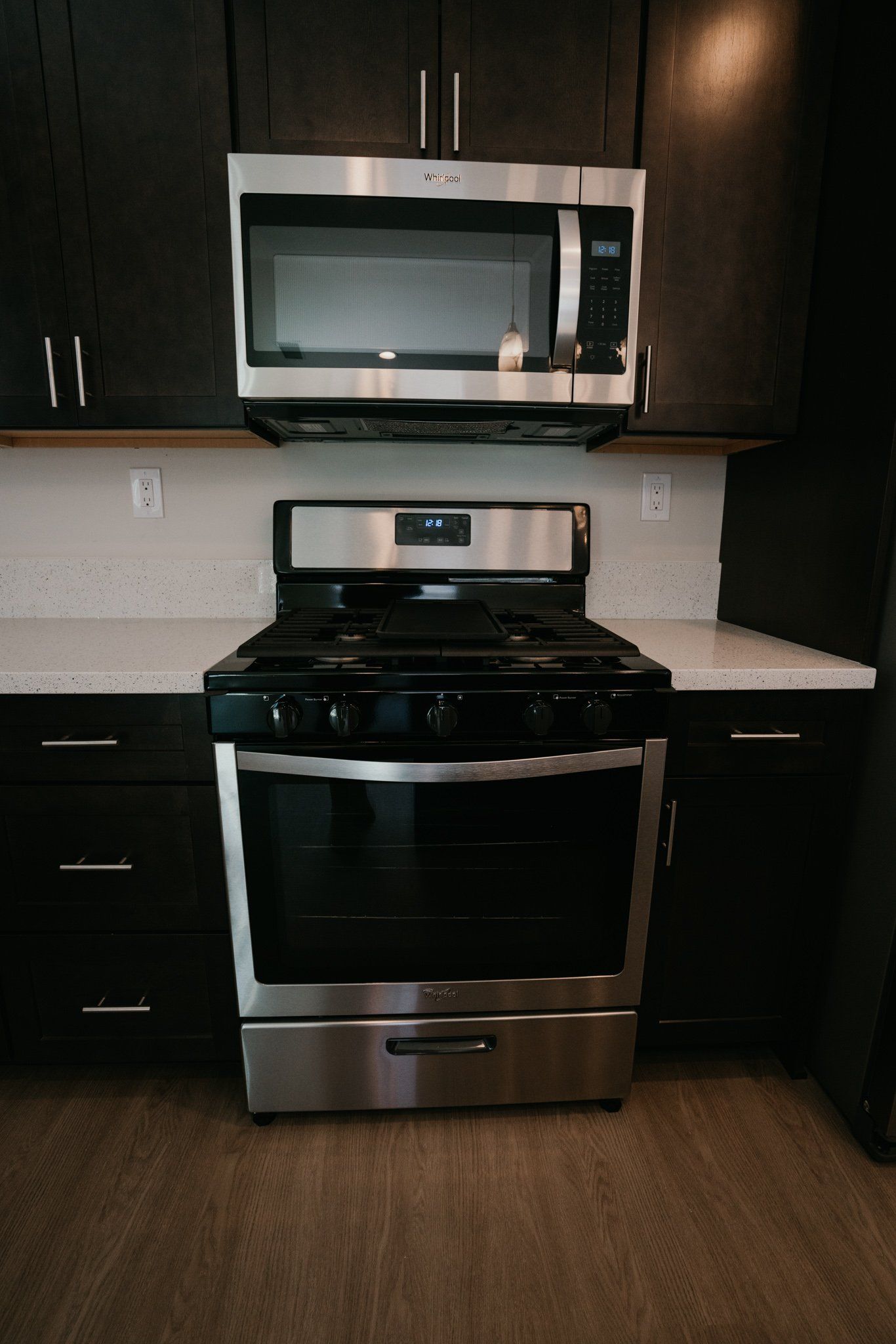 A stove with a microwave above it in a kitchen