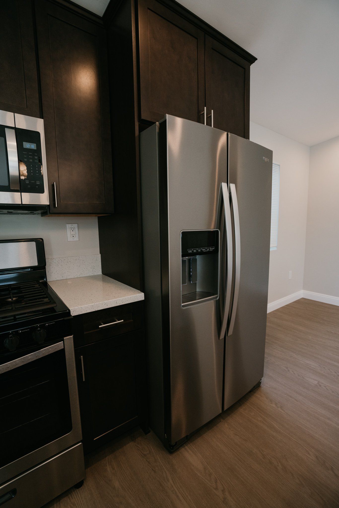 A kitchen with a stainless steel refrigerator , stove and microwave.