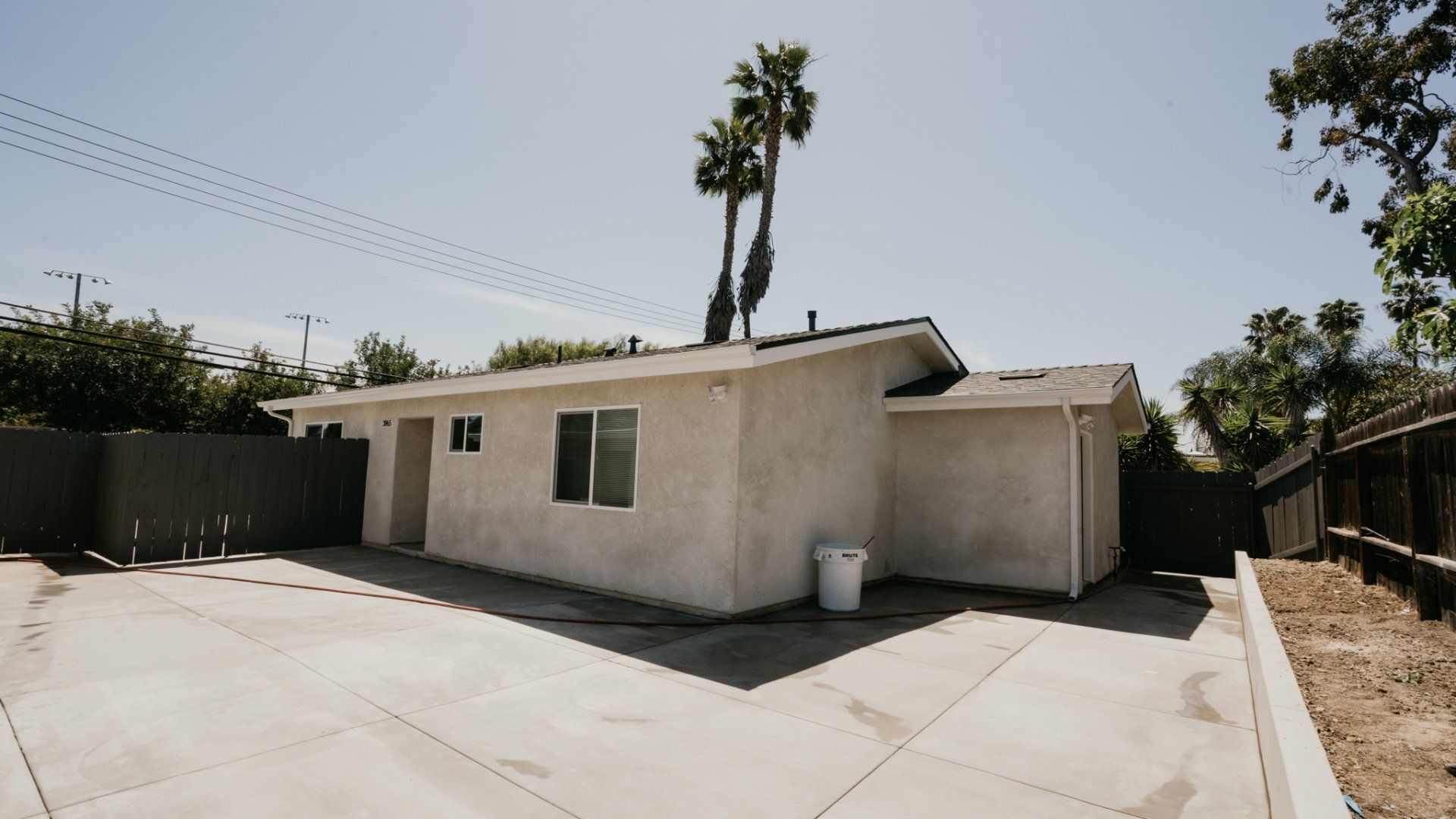 A white house with a concrete driveway in front of it