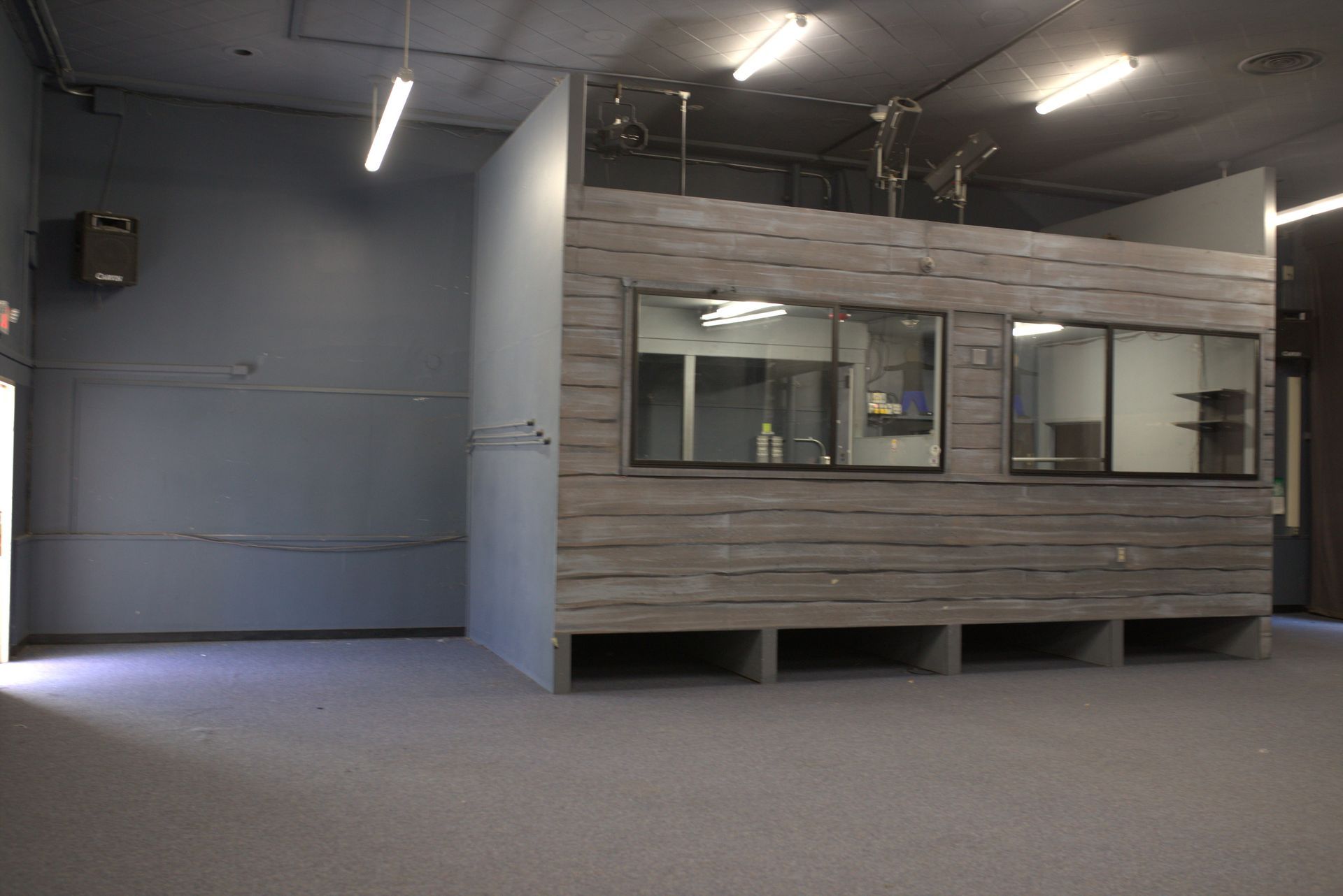 An empty room with a wooden wall and windows