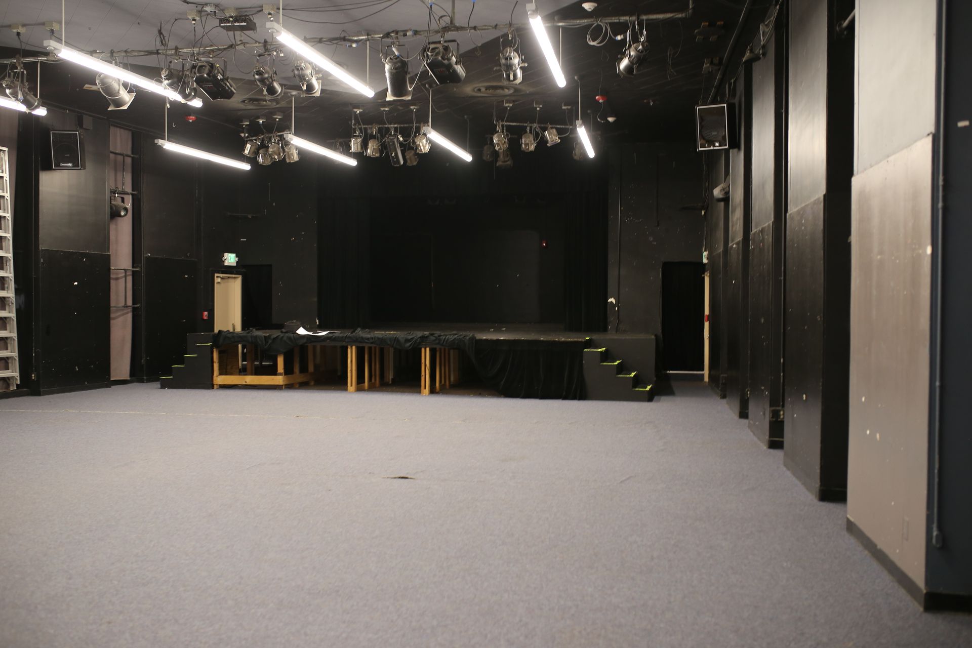 A large empty room with a stage in the background