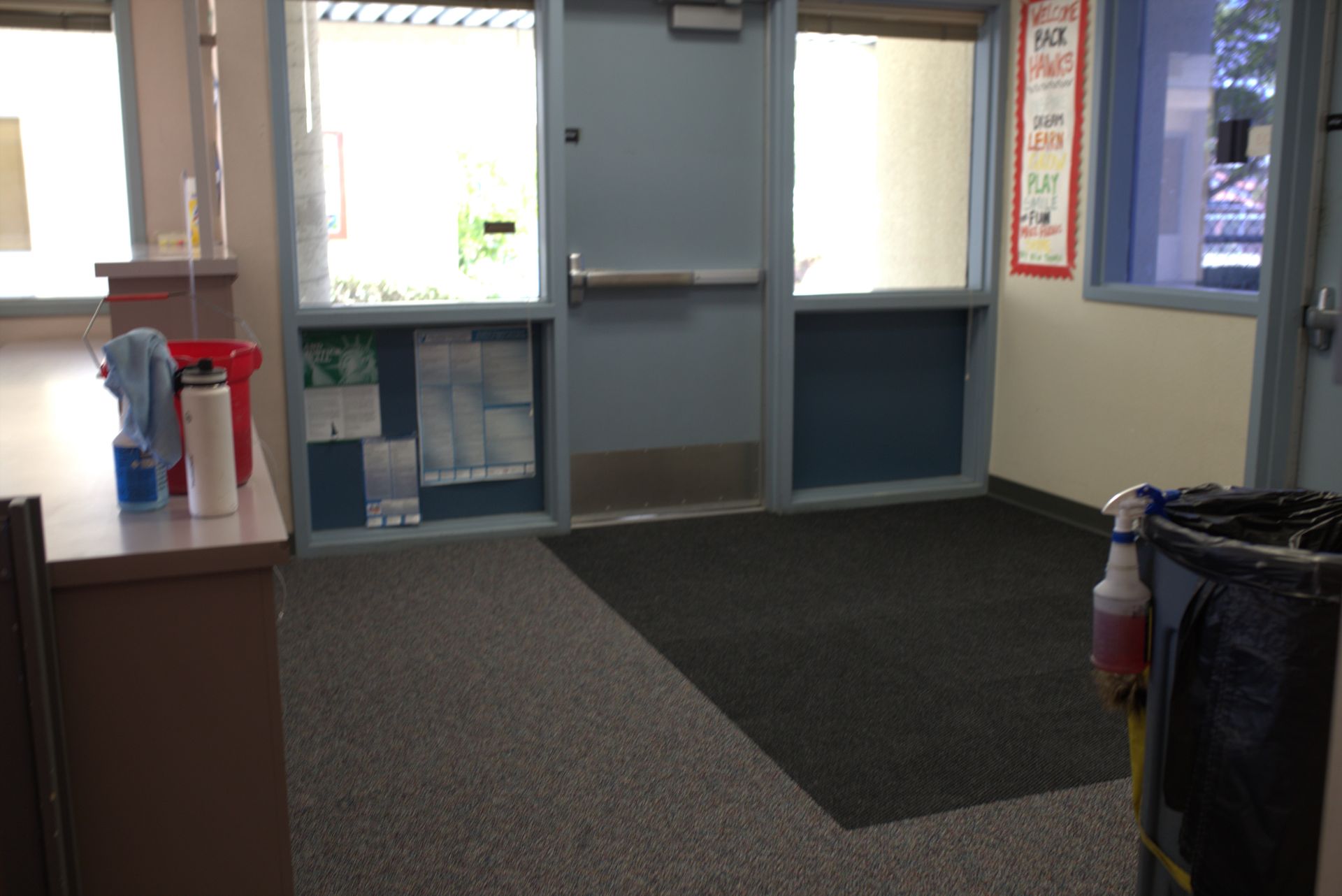 A room with a door and a trash can in it