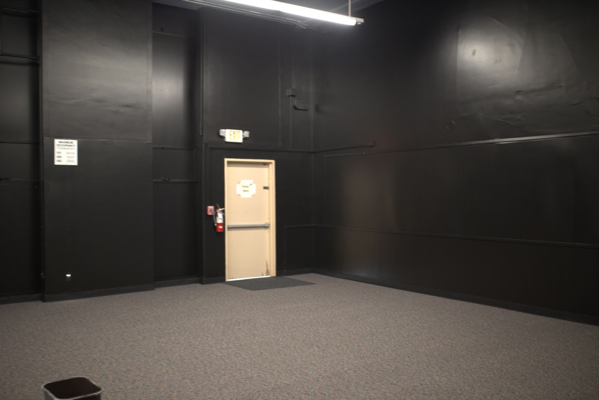 An empty room with black walls and a door