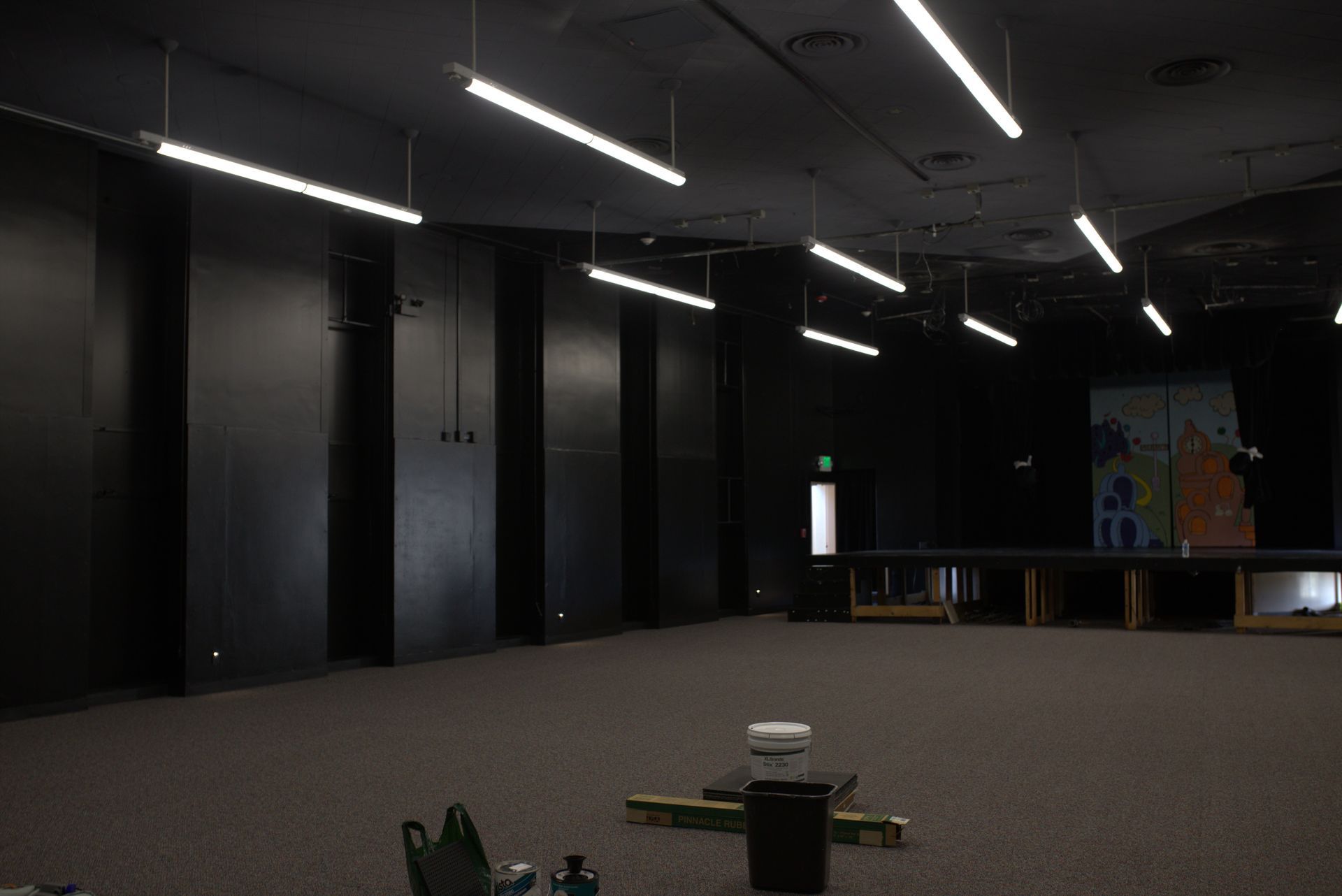A large empty room with a lot of lights hanging from the ceiling