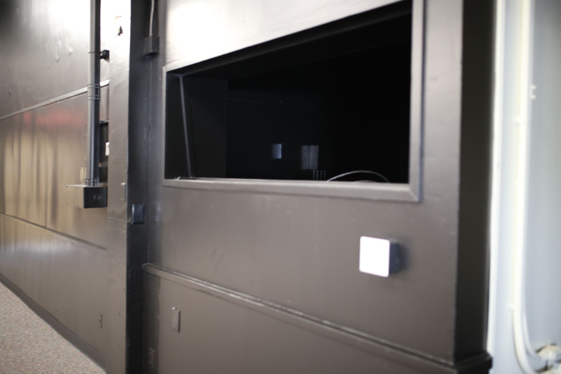 A black wall with a small window on it