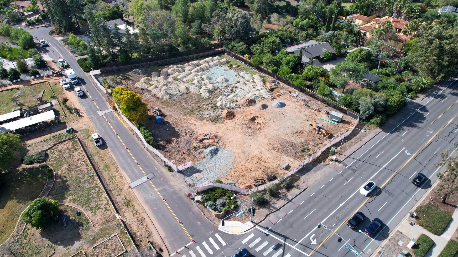 An aerial view of a residential area with a lot of cars on the road.