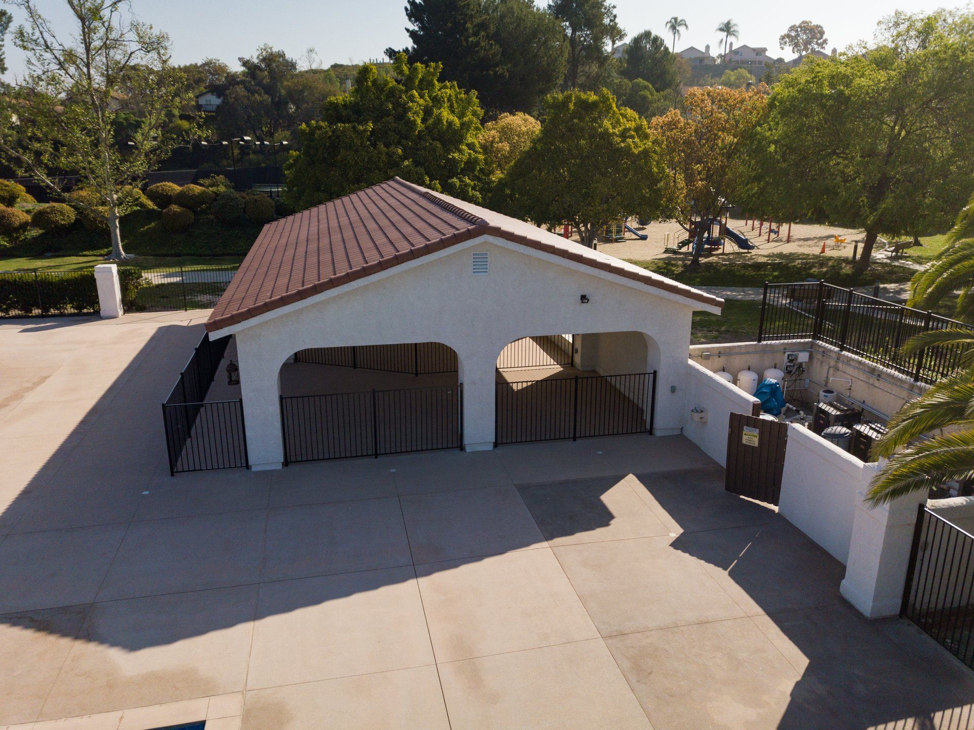 An aerial view of a white building with a red roof