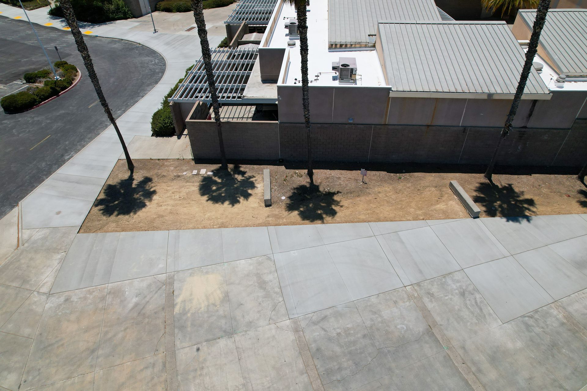 Street corner with sidewalk, low wall, and building beside a road