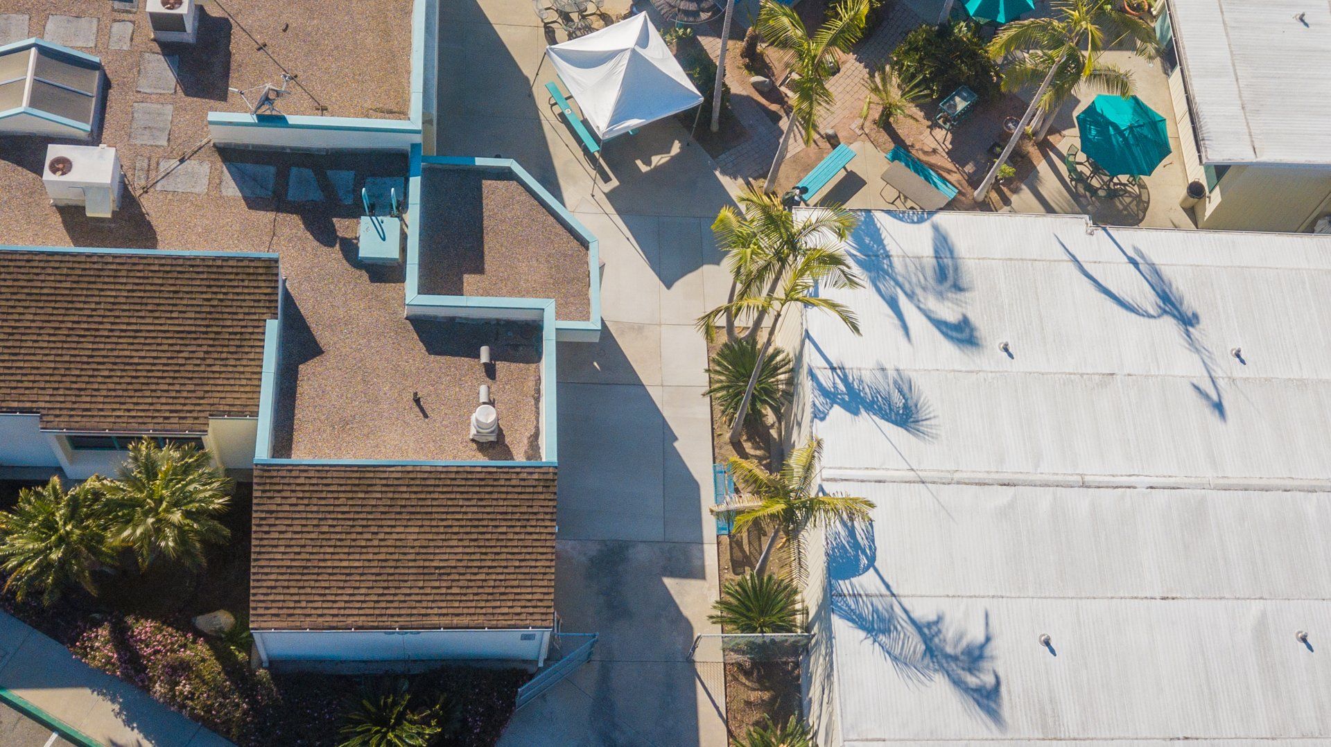 An aerial view of a residential area with a lot of buildings and palm trees.
