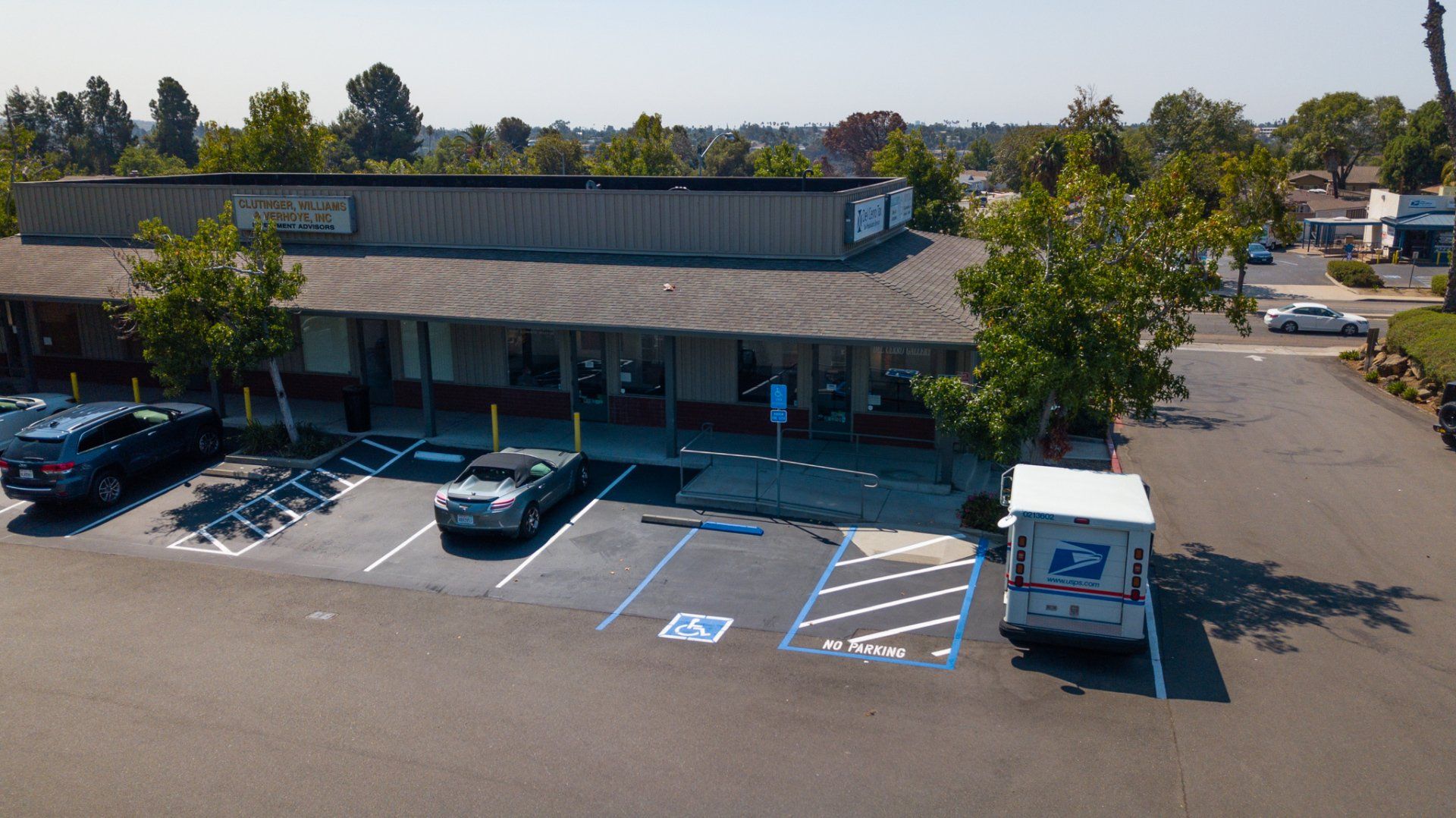 An aerial view of a parking lot in front of a building