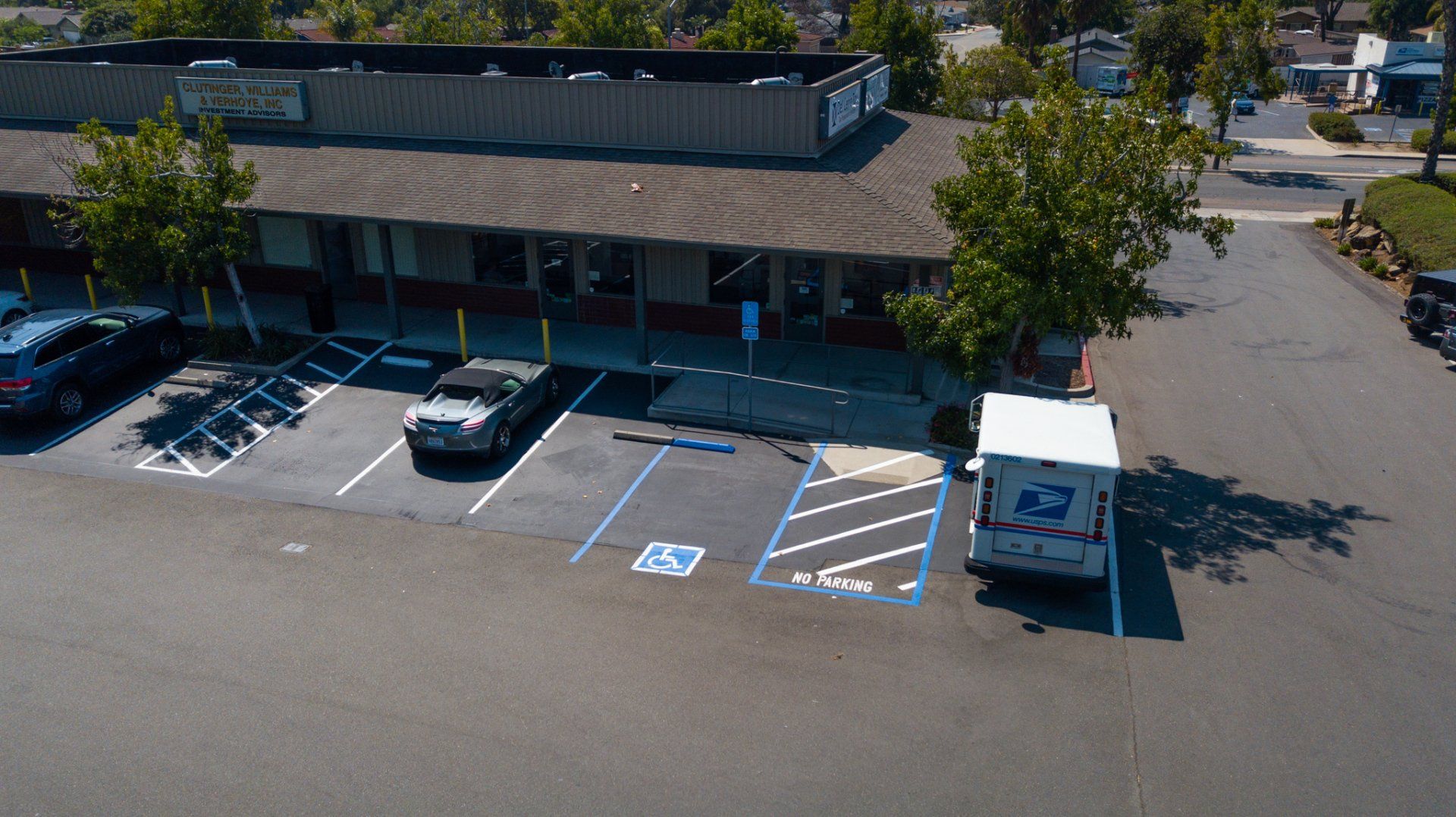 An aerial view of a parking lot with a usps truck