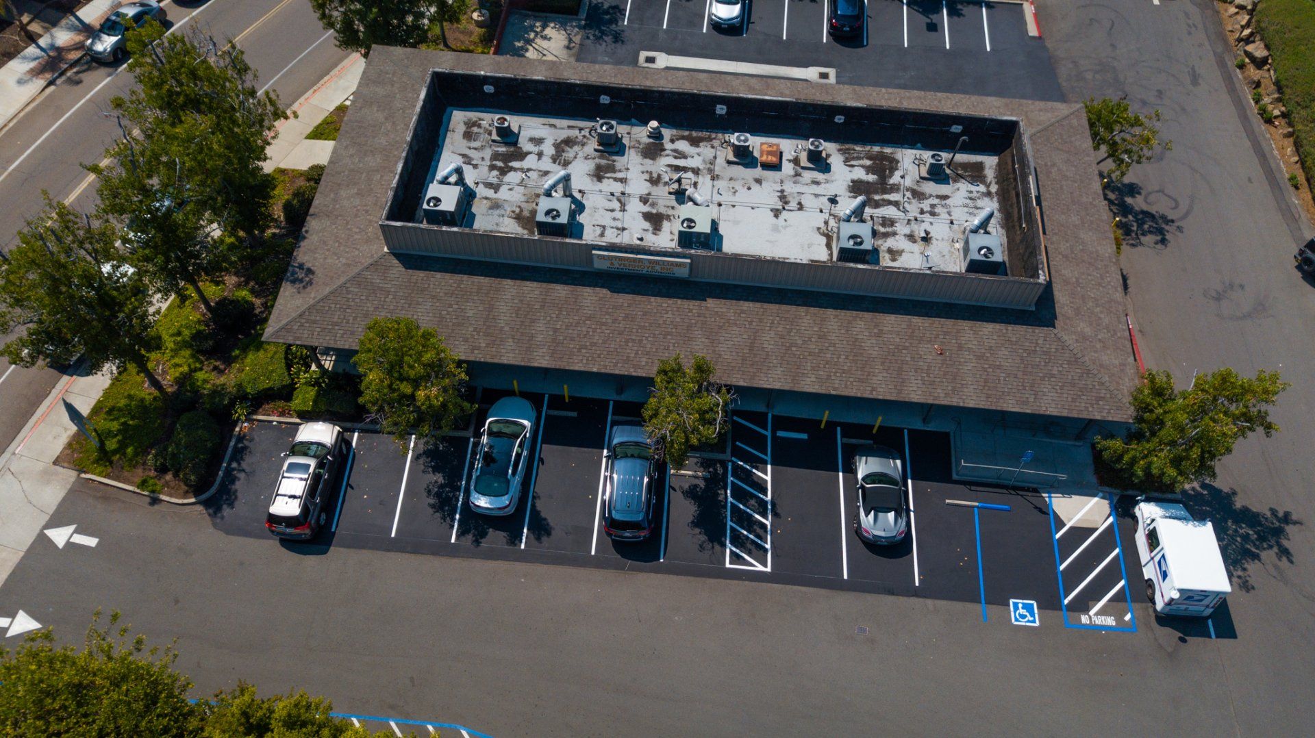 An aerial view of a parking lot with a building in the background