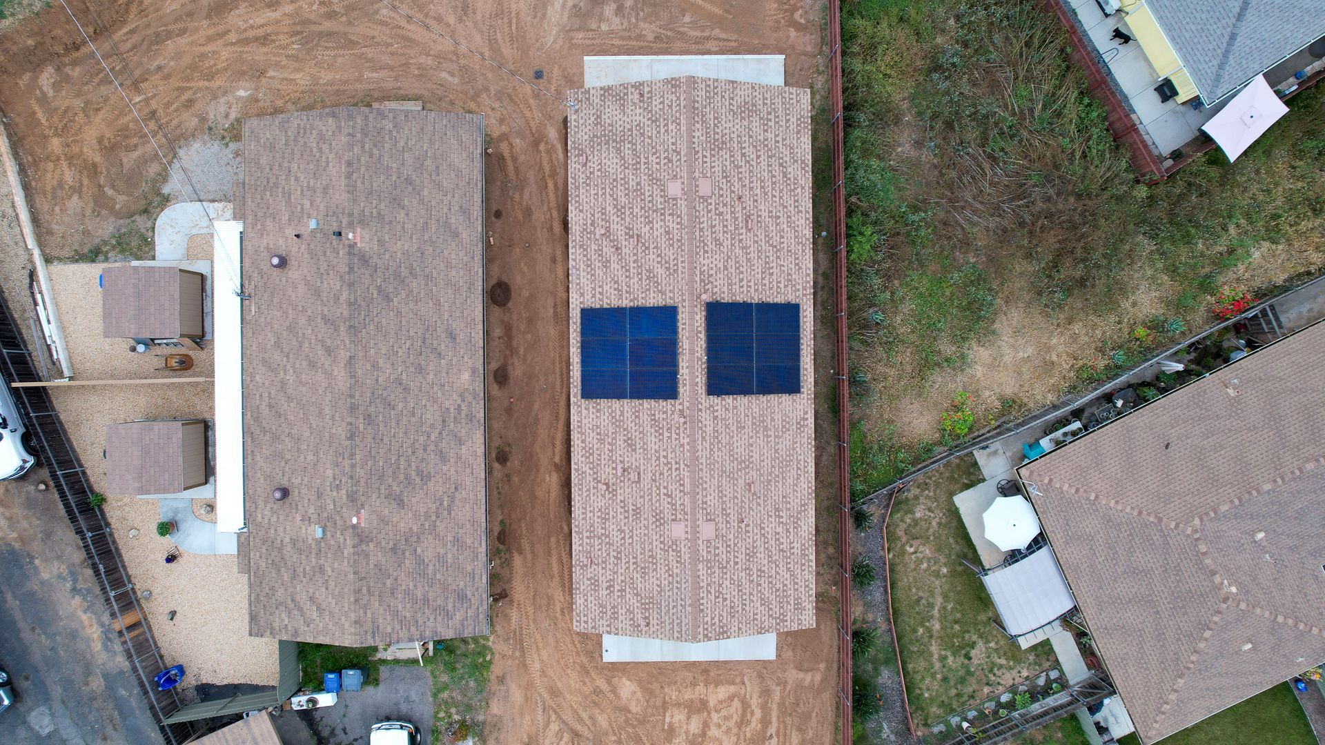 An aerial view of a house with two solar panels on the roof