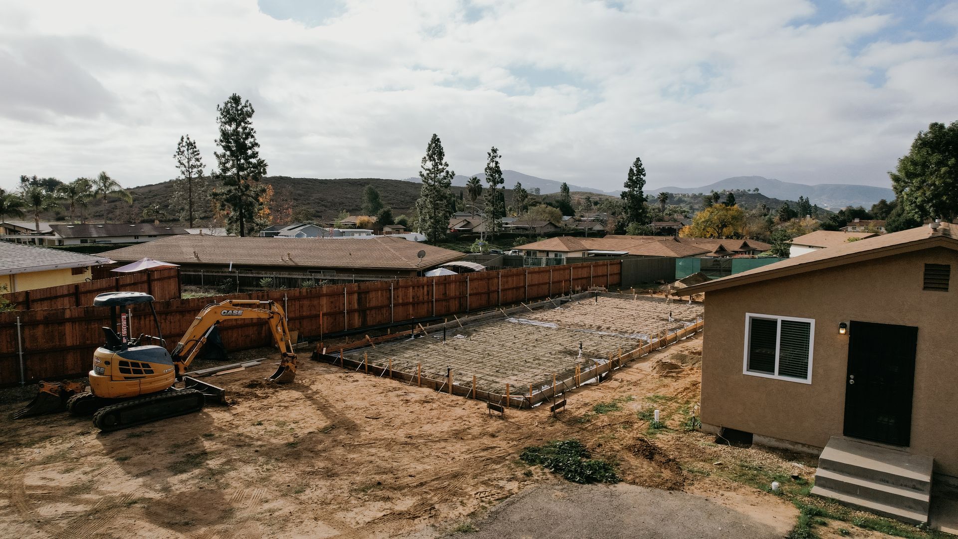 A construction site with a house in the background