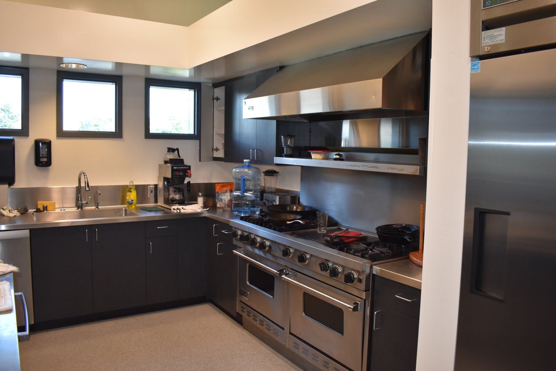 A kitchen with stainless steel appliances and black cabinets