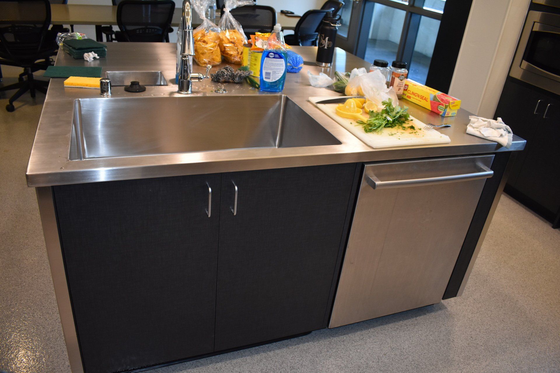 A kitchen counter with a sink and a cutting board