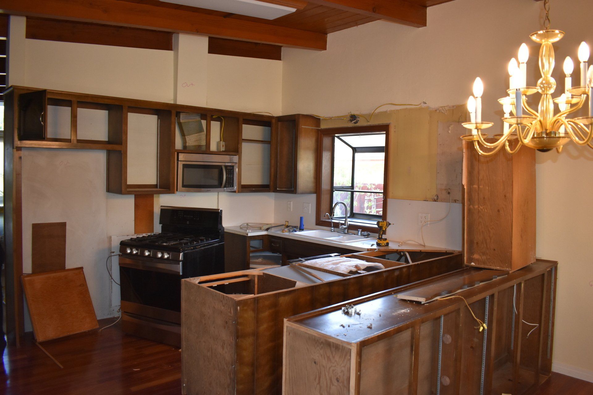 A kitchen with a stove and a chandelier hanging from the ceiling