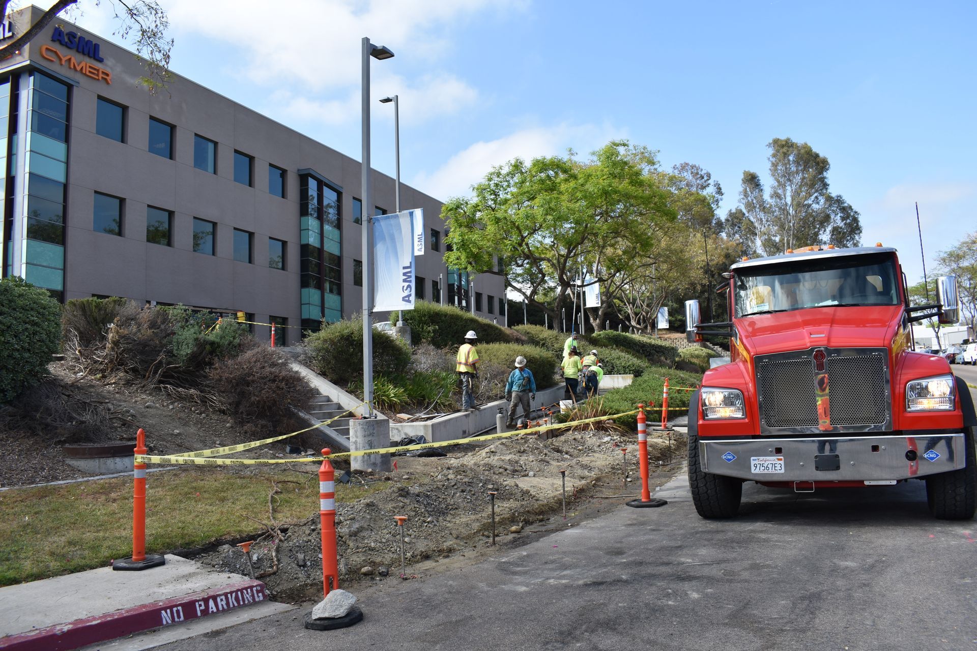 A red truck is parked in front of a building that says dhl