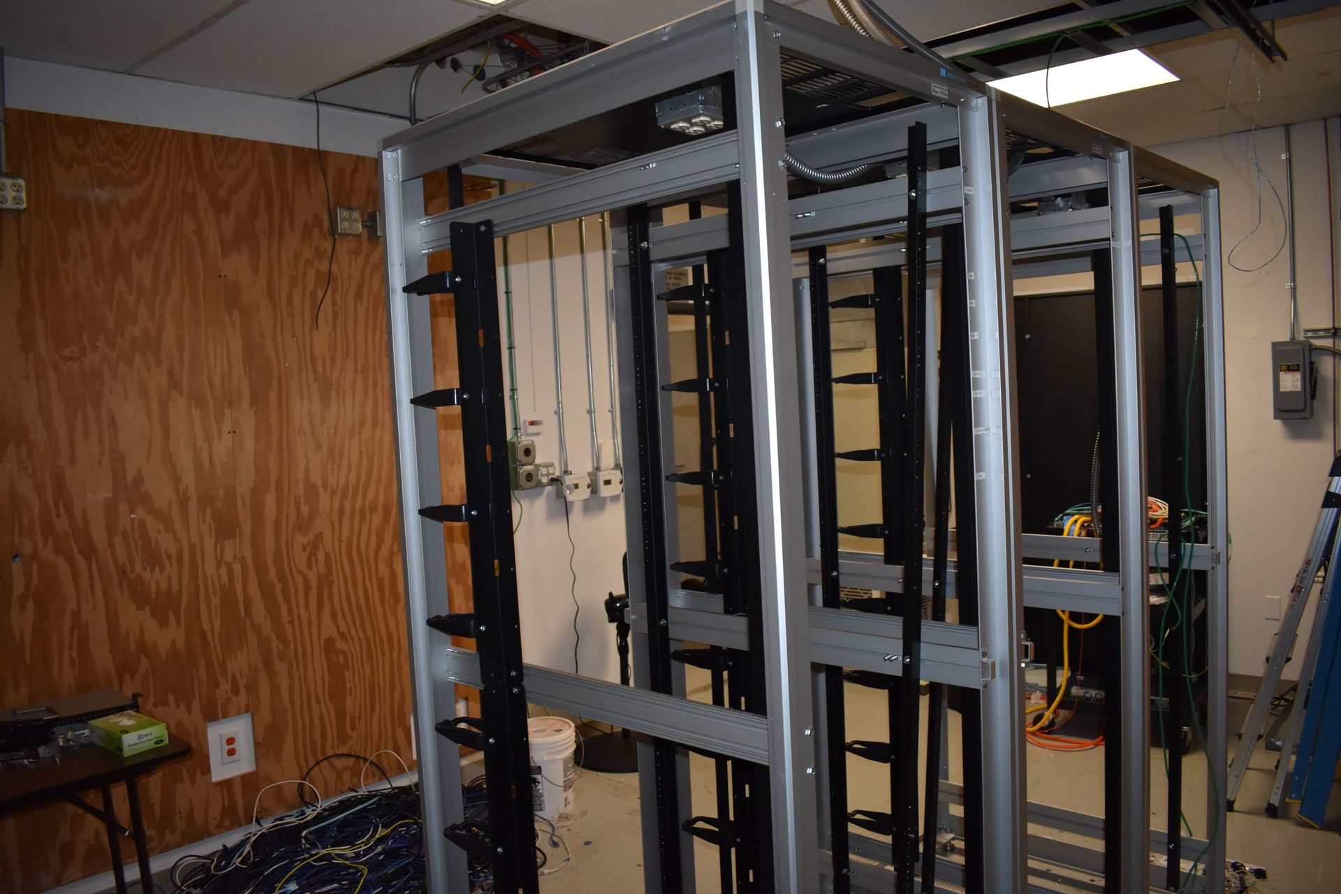 A metal frame is sitting in a room next to a wooden wall.