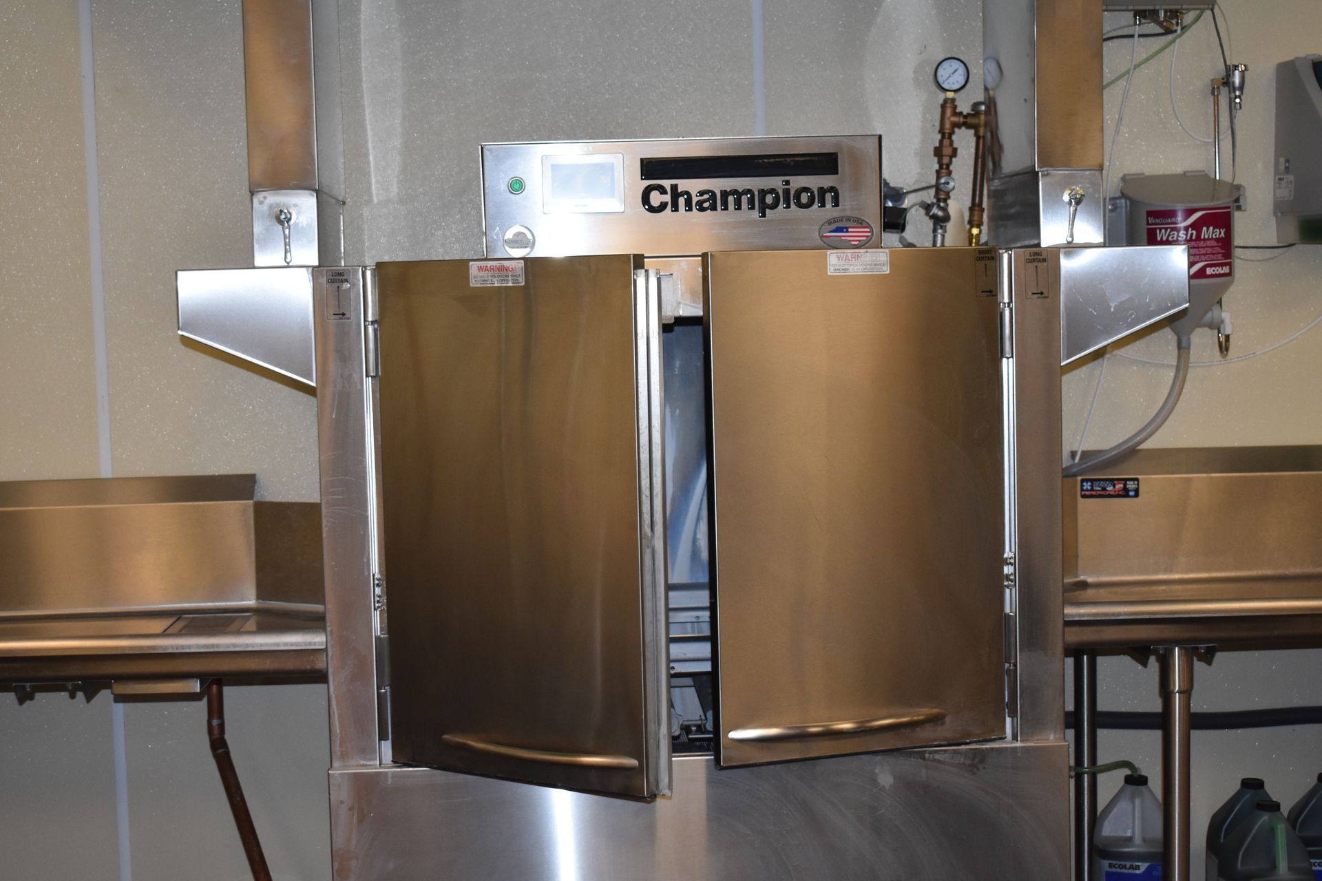 A stainless steel champion dishwasher with its doors open