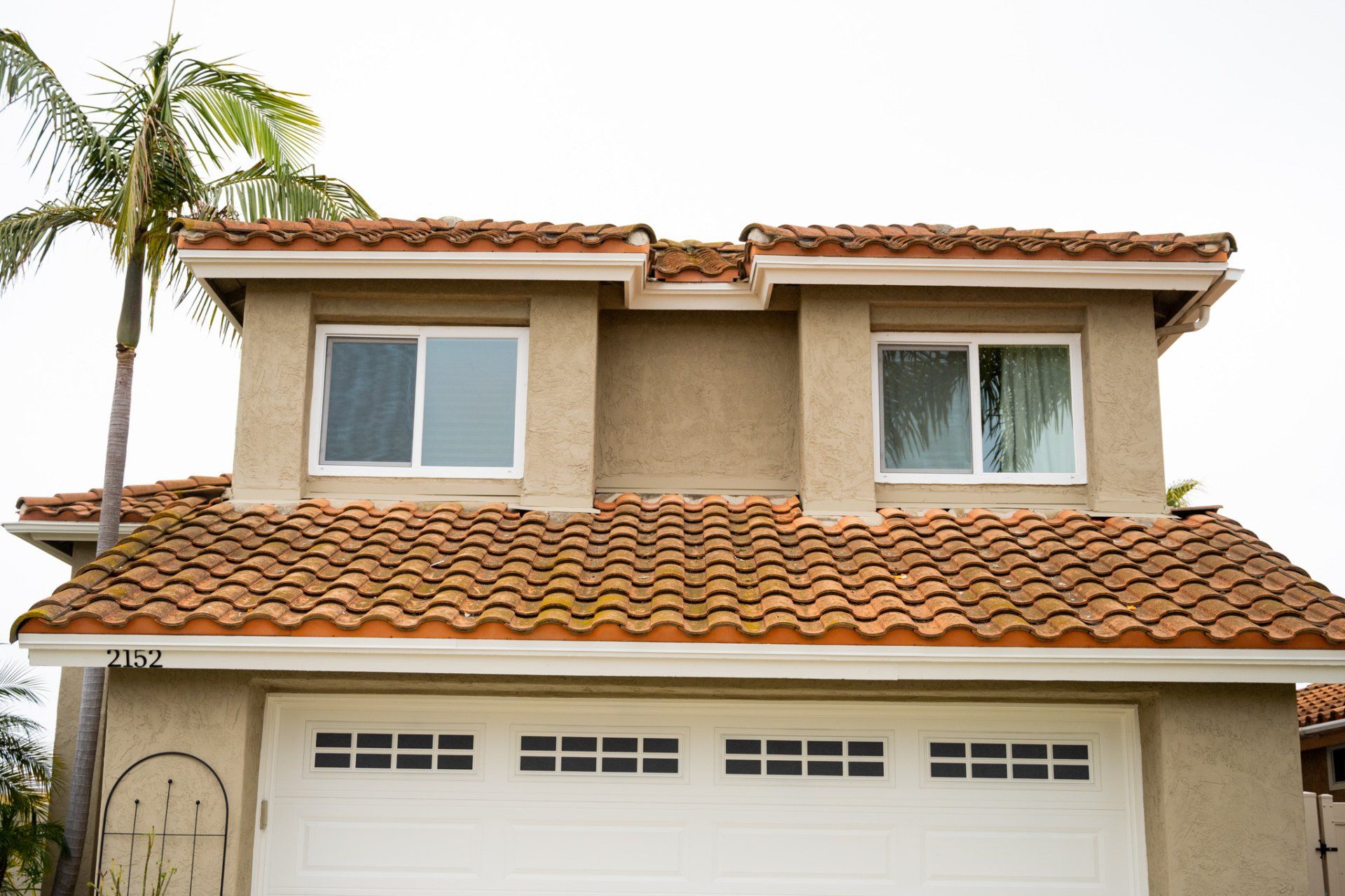 A house with a tiled roof and a white garage door