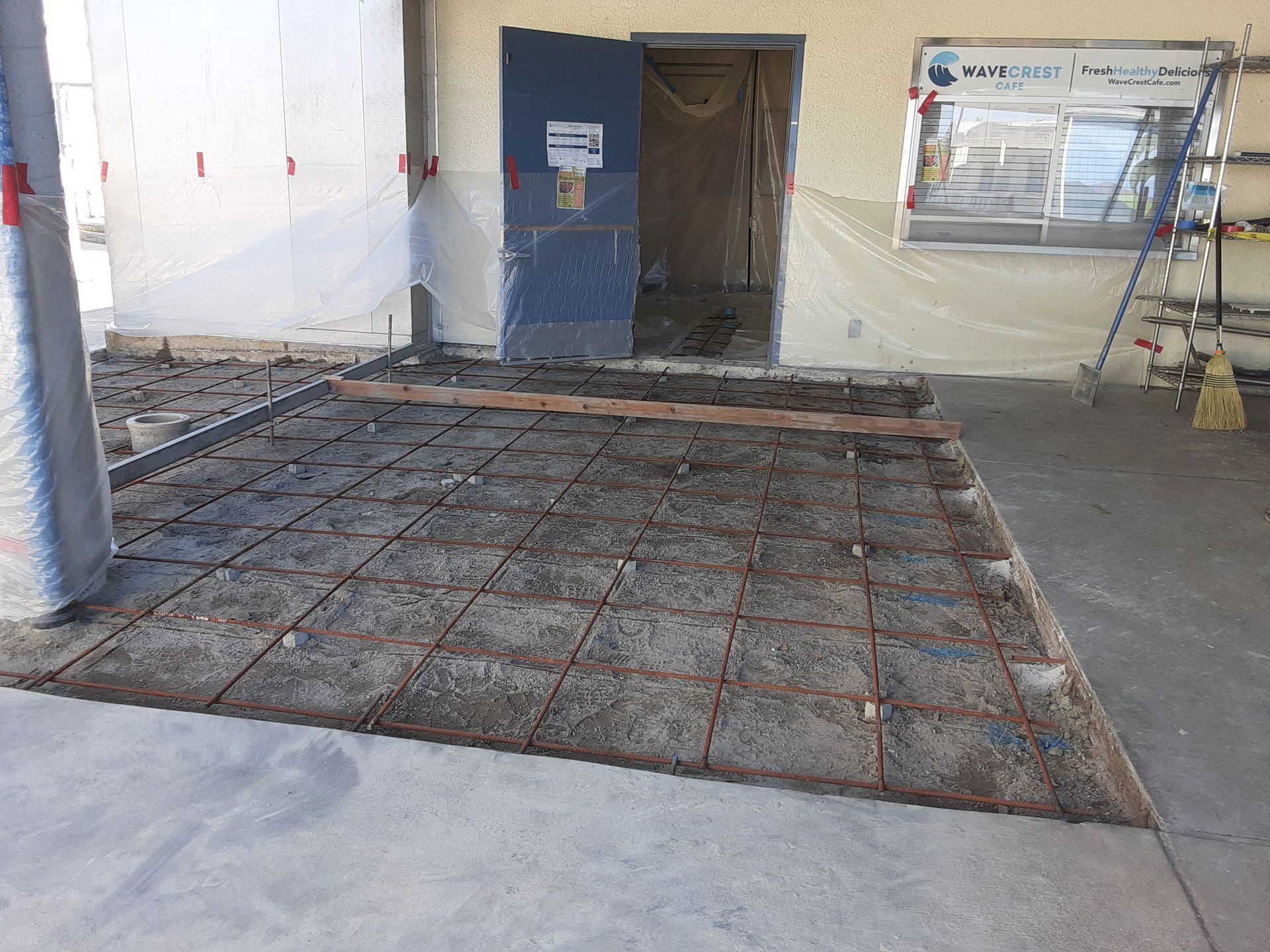 A concrete floor is being built in front of a building.