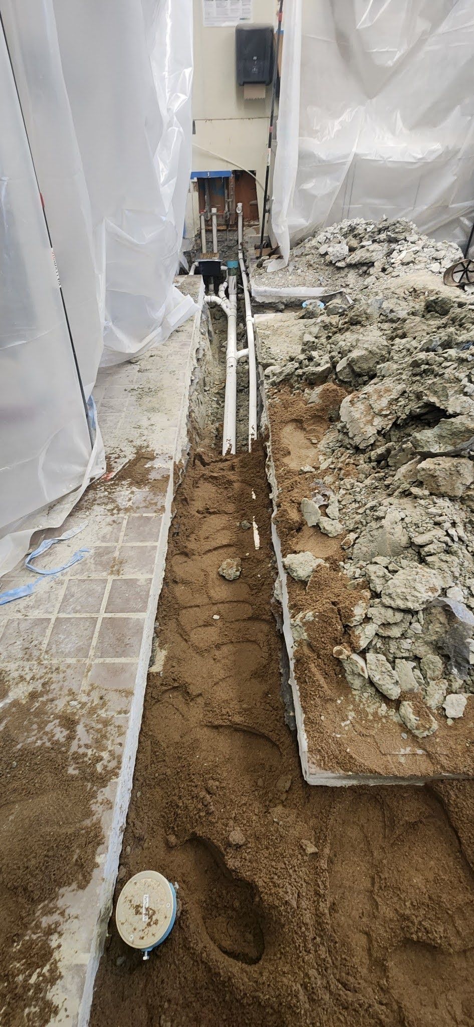 A drain pipe is being installed in a basement.