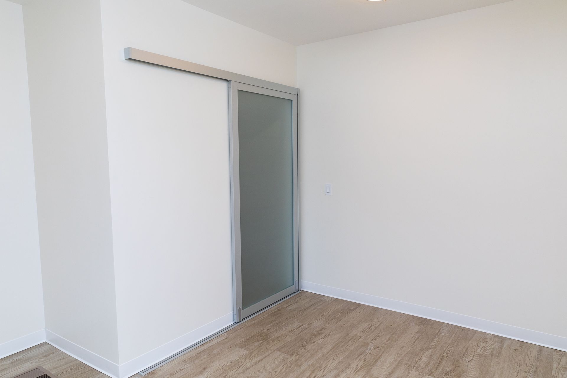 There is a sliding glass door in the corner of the room.