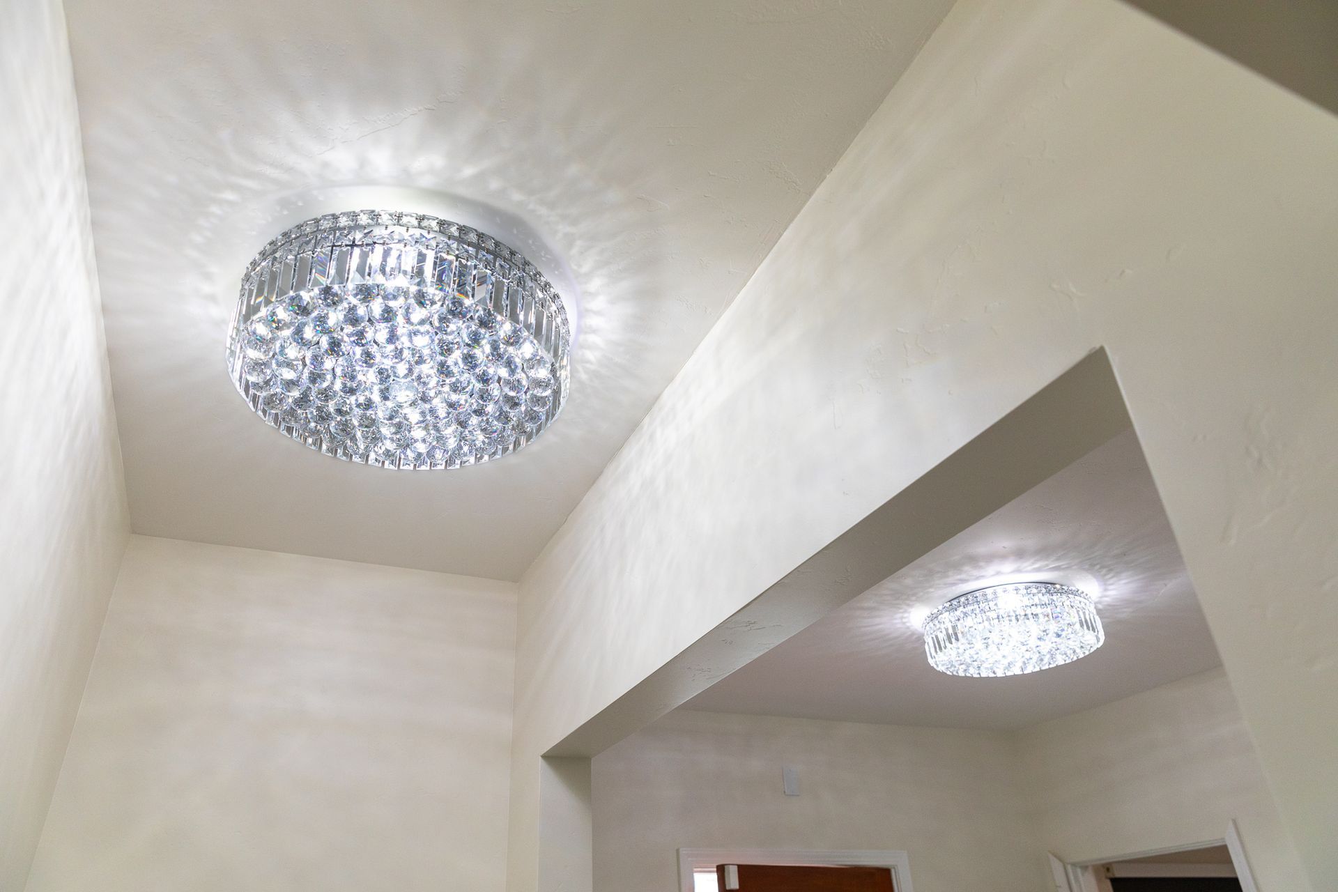 A chandelier is hanging from the ceiling of a hallway.