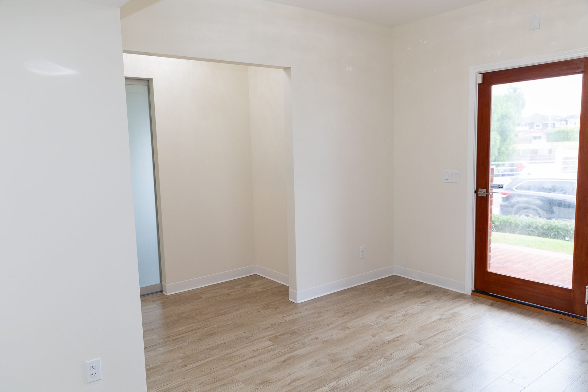 An empty room with a wooden floor and a door.