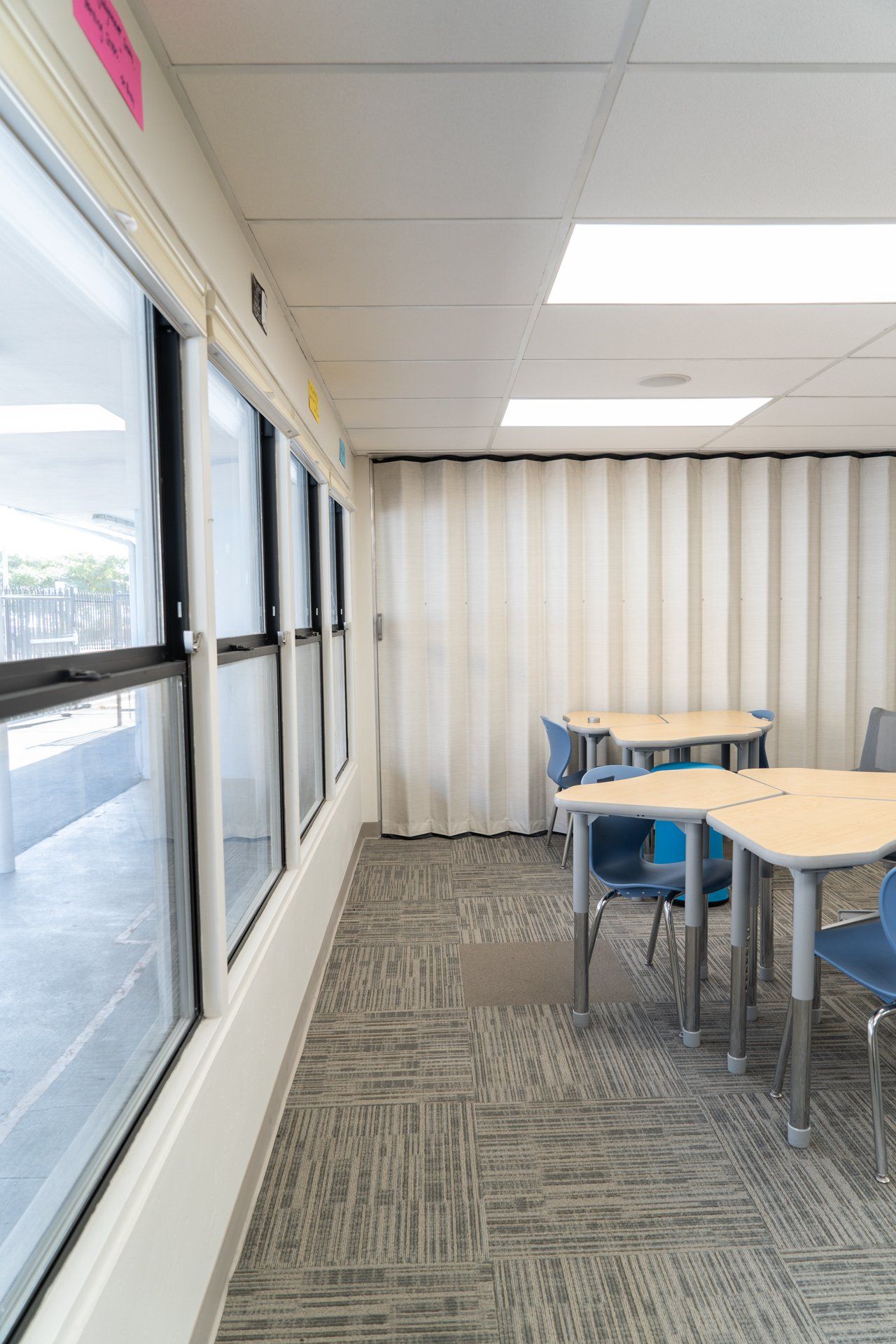 A long hallway with tables and chairs in a room.