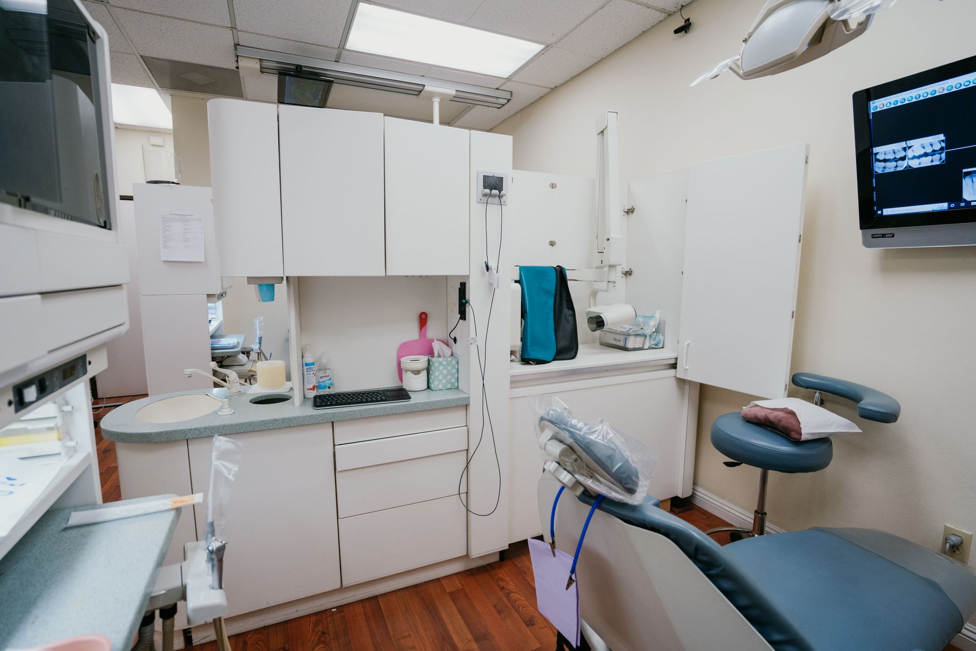 A dental office with a dental chair and a television on the wall.
