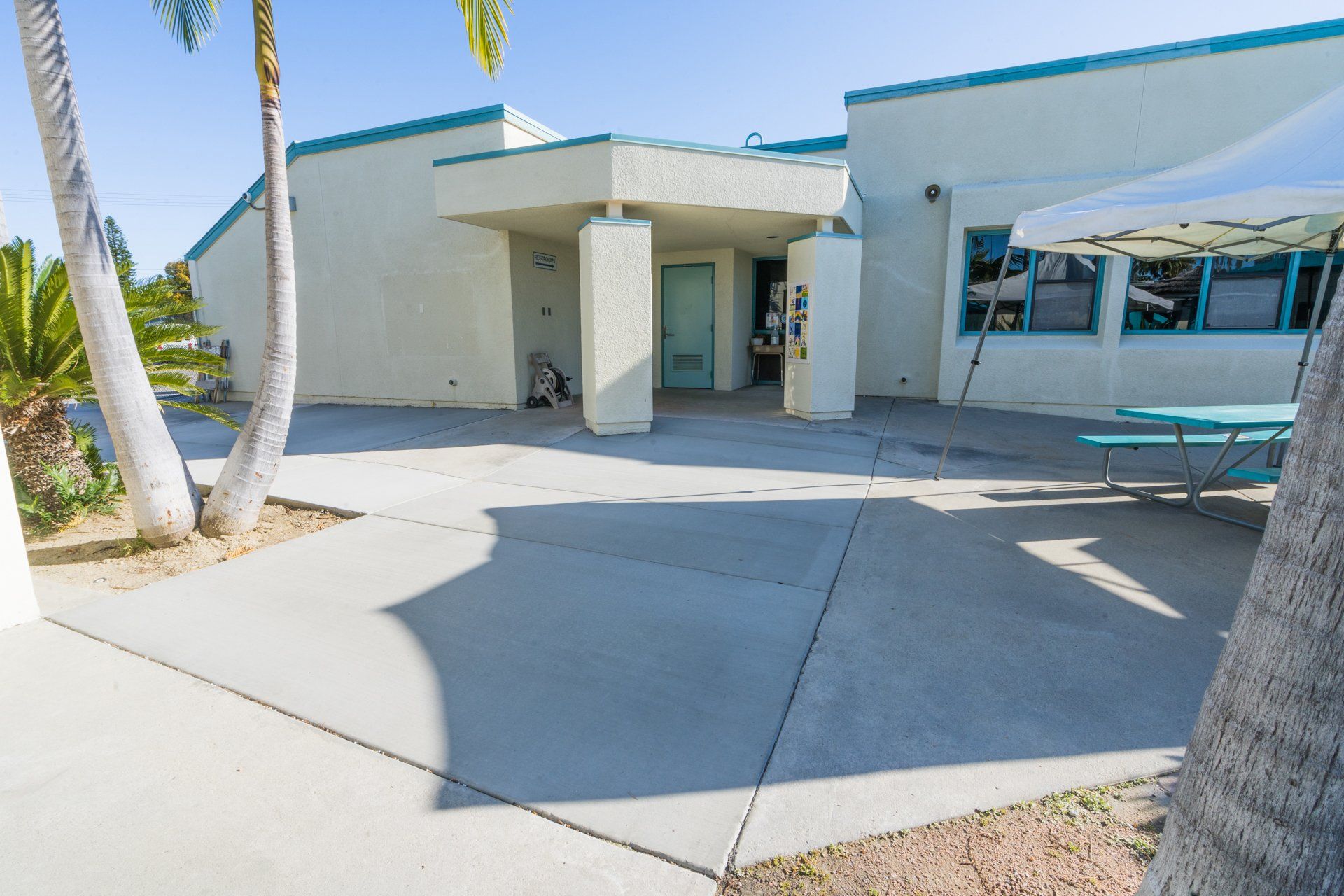 A white building with a picnic table in front of it
