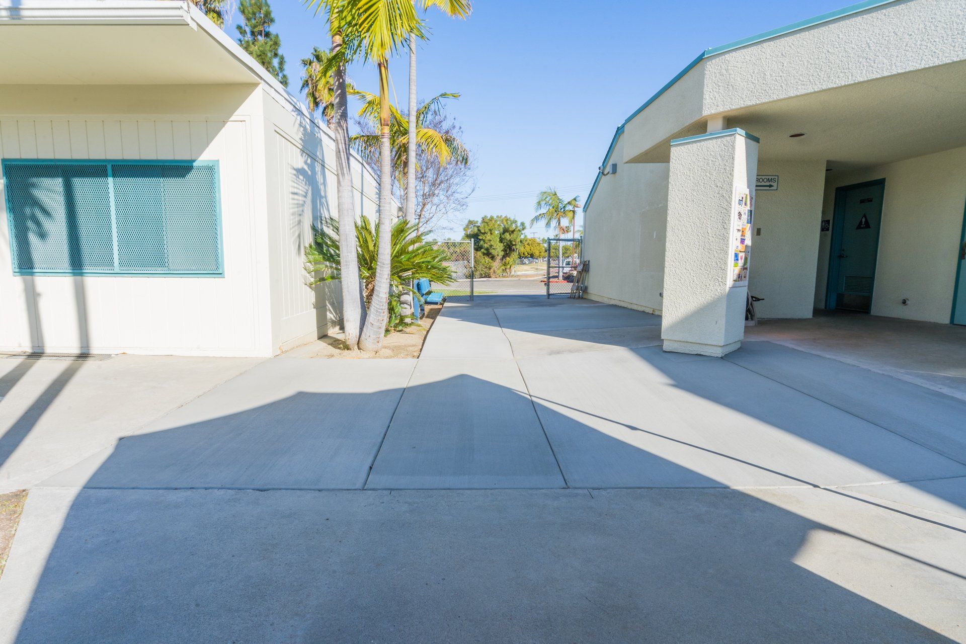 A concrete walkway between two buildings on a sunny day