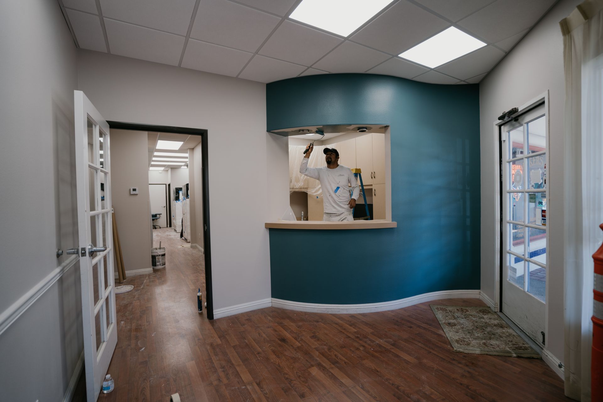 A man is painting a wall in a room.