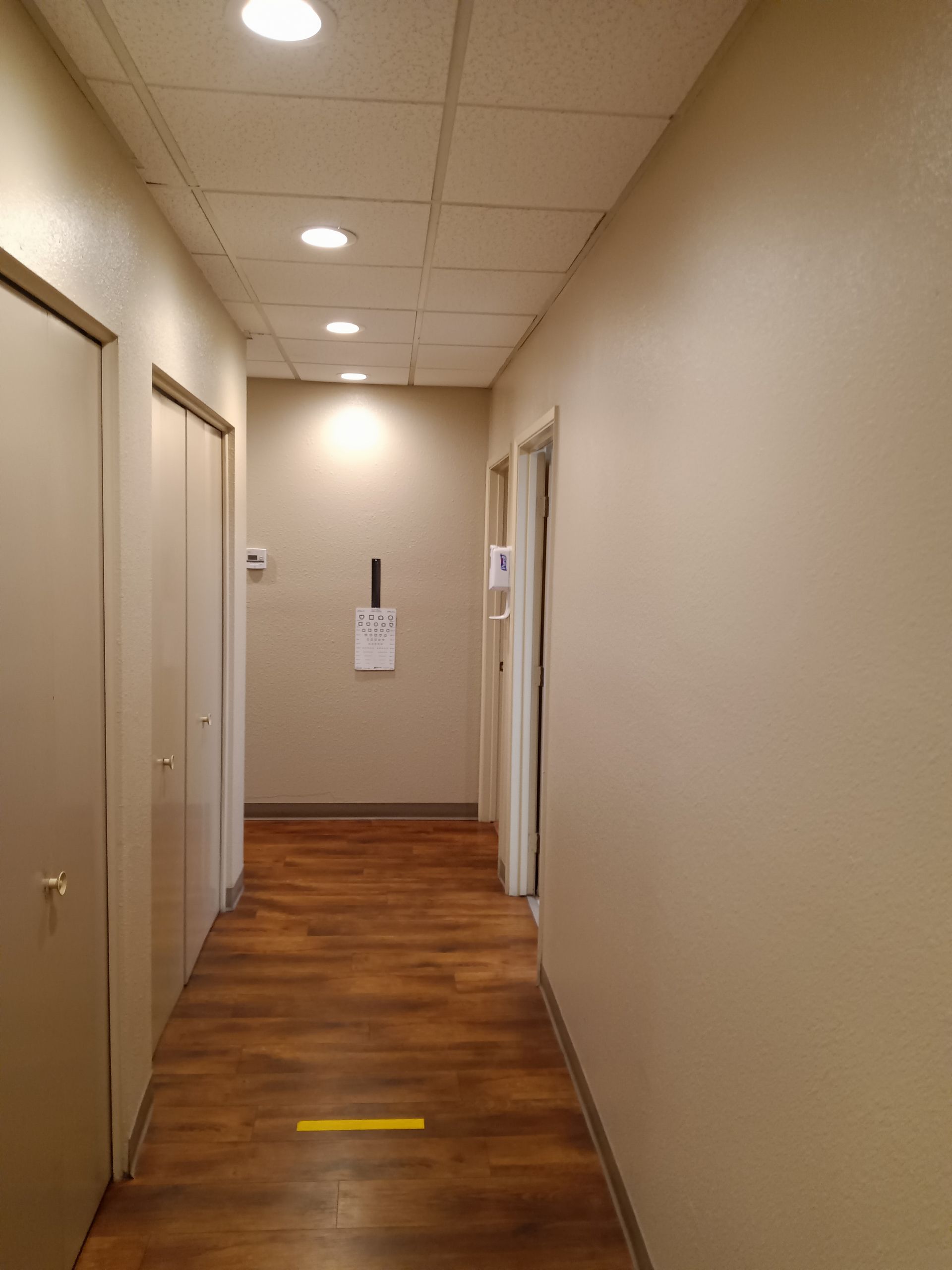 A long hallway with wooden floors and beige walls