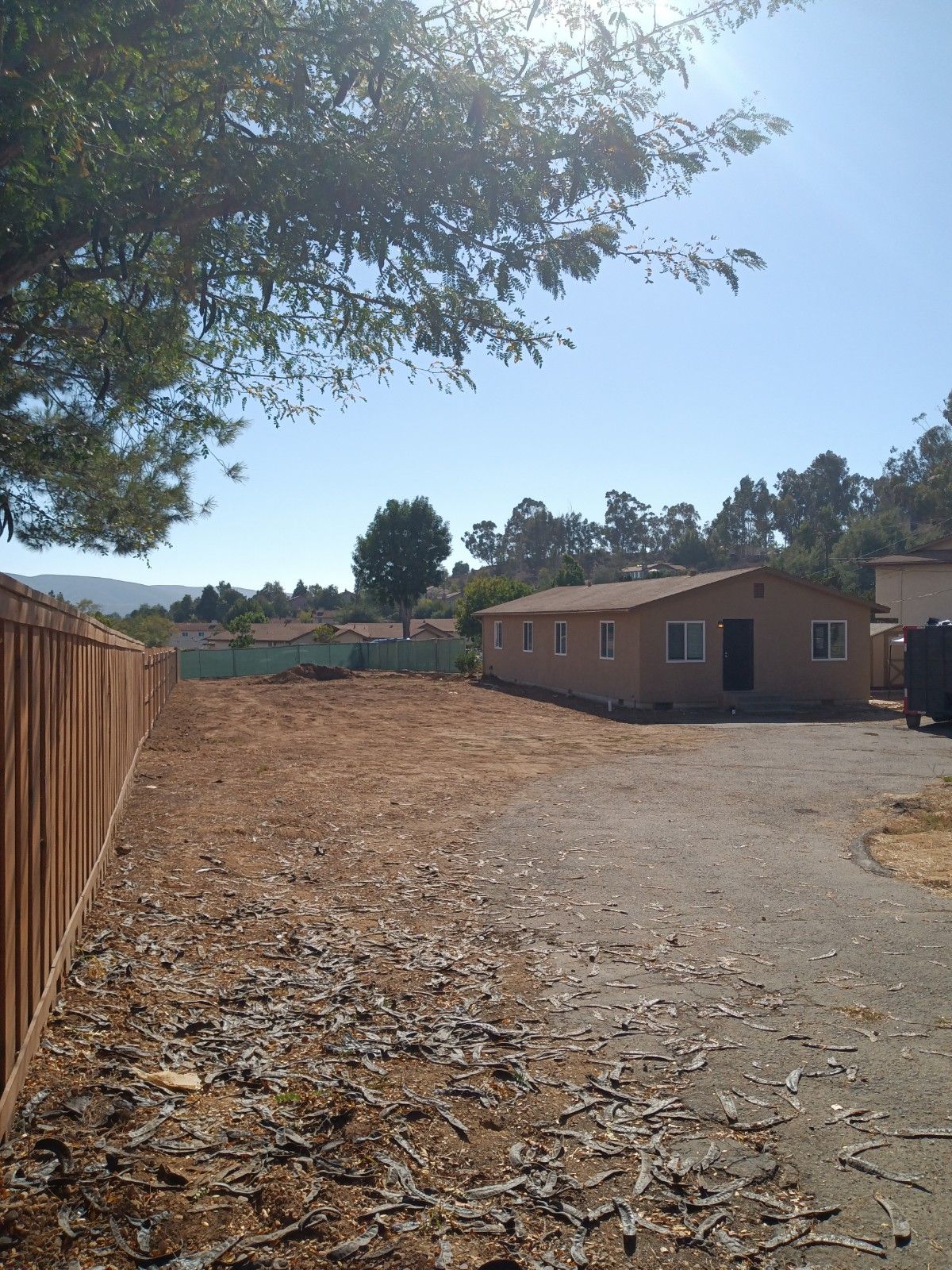 A fenced in yard with a house in the background