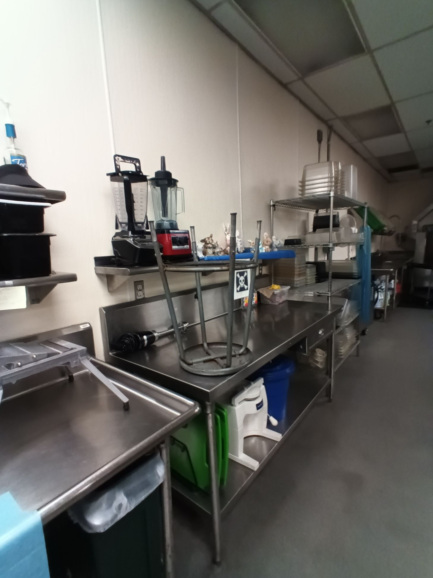 A kitchen with stainless steel counters and blenders