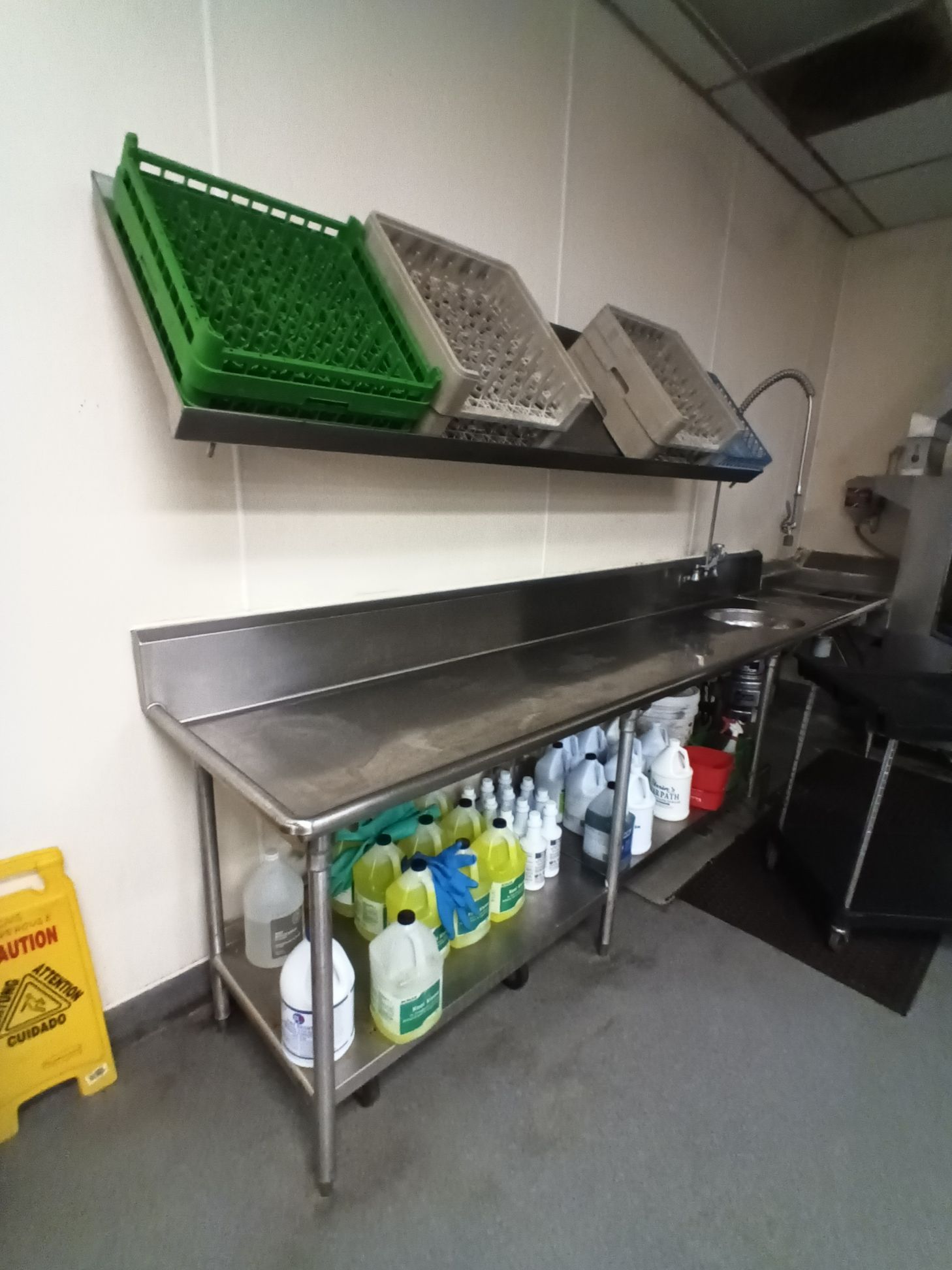 A kitchen with a yellow caution sign on the floor