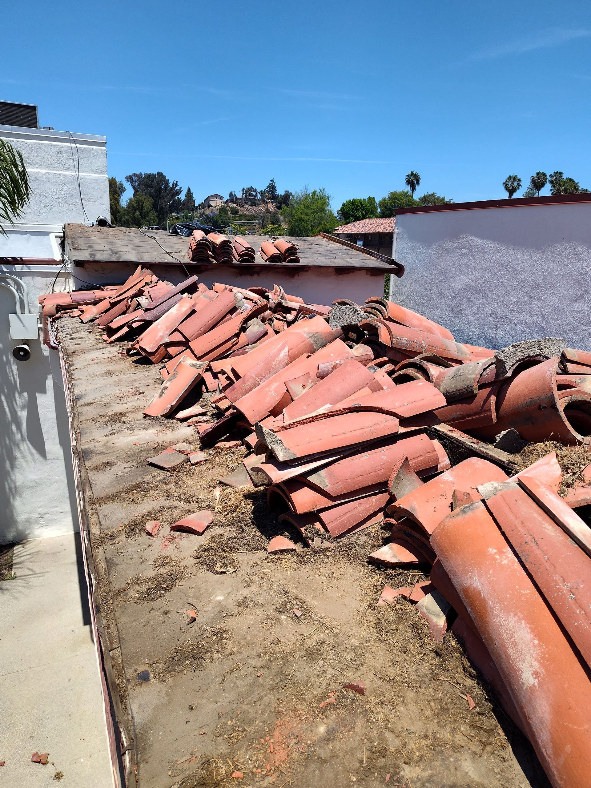 A pile of broken tiles on the roof of a building.