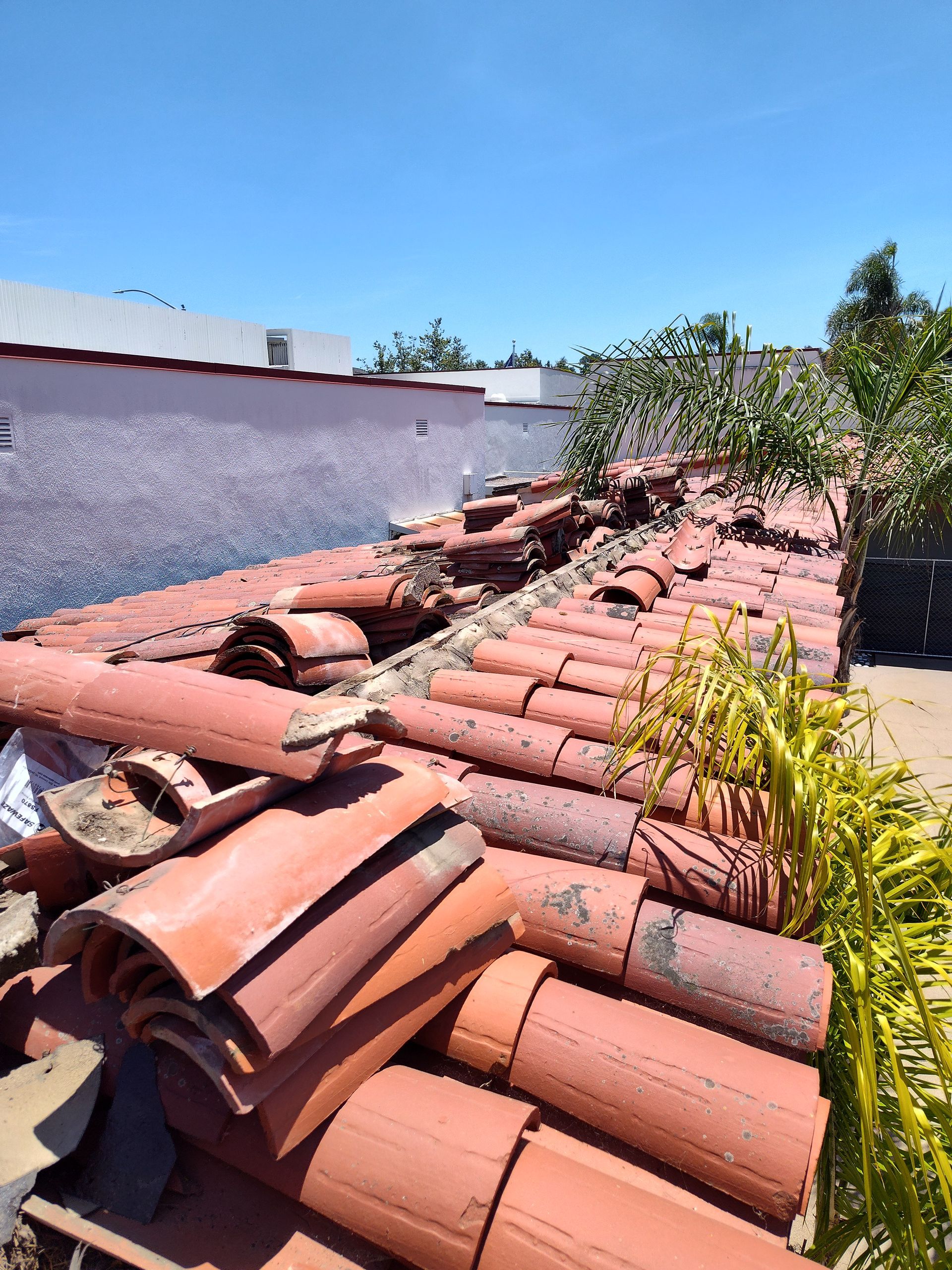 A pile of red tiles on the roof of a house.