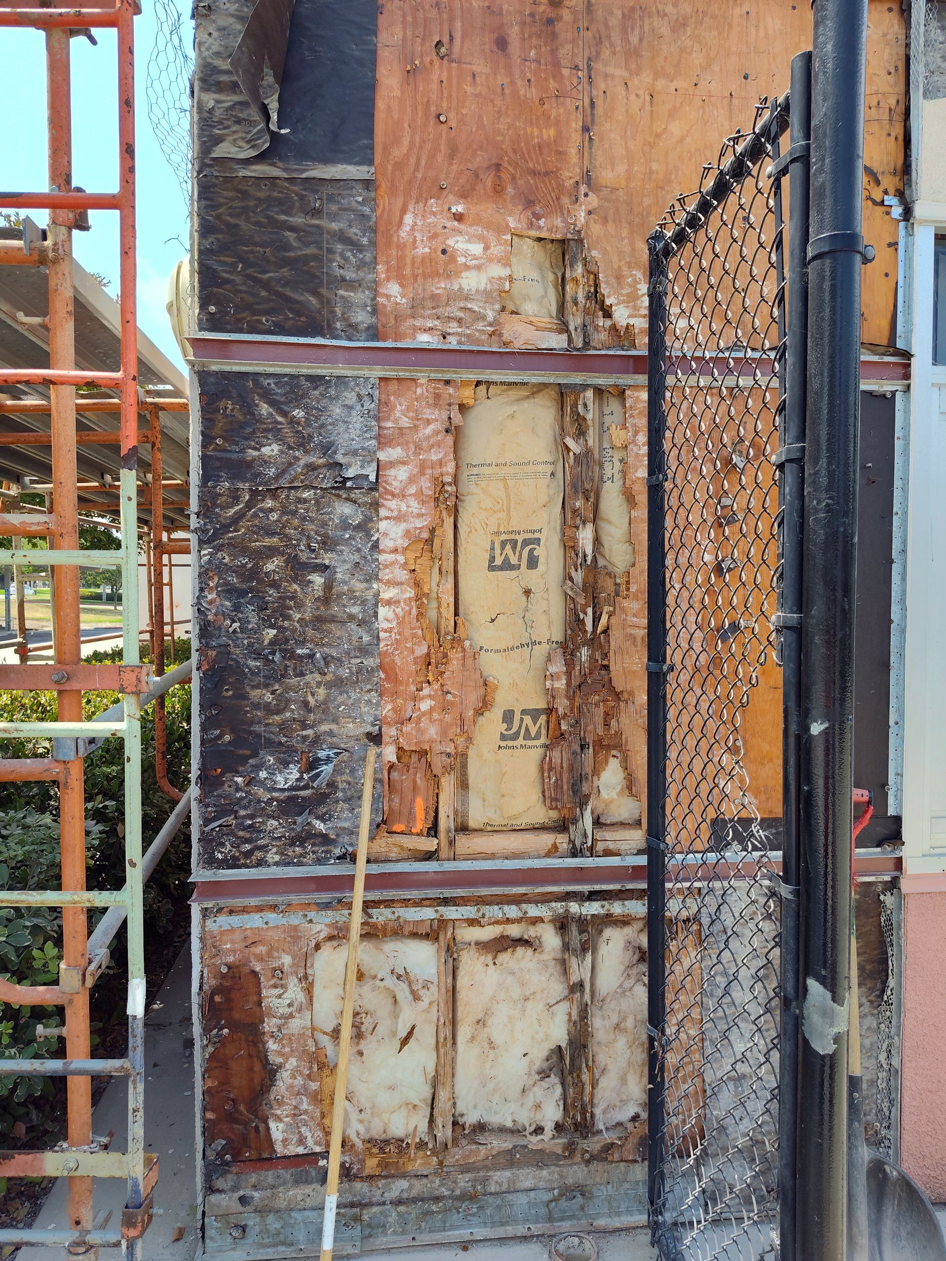 A scaffolding is behind a building that is being demolished