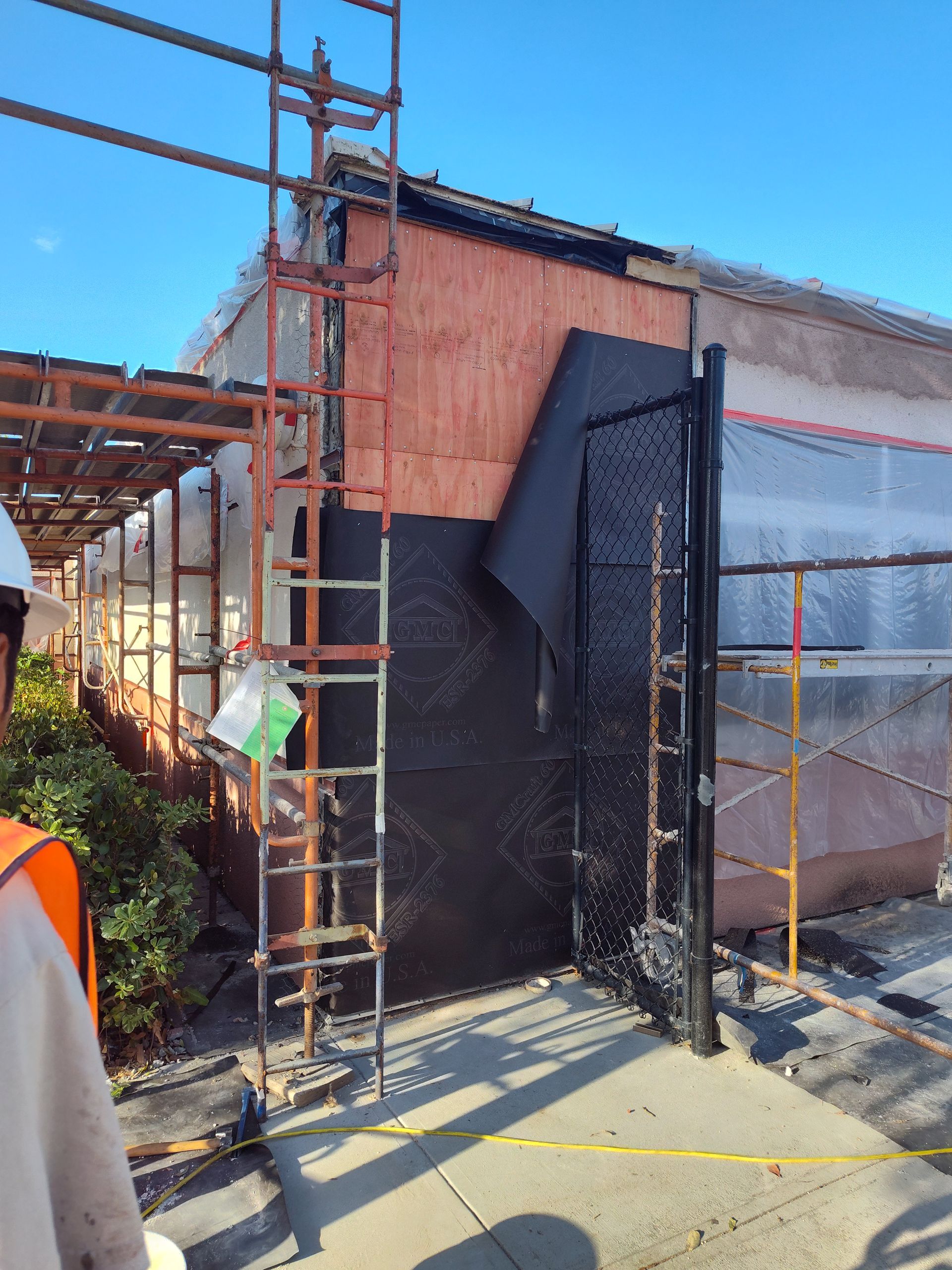 A man is standing in front of a building under construction