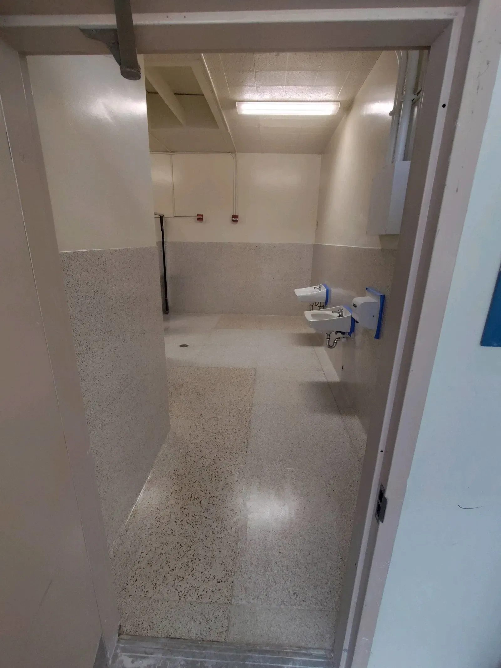 A bathroom with two sinks and a shower in a building.