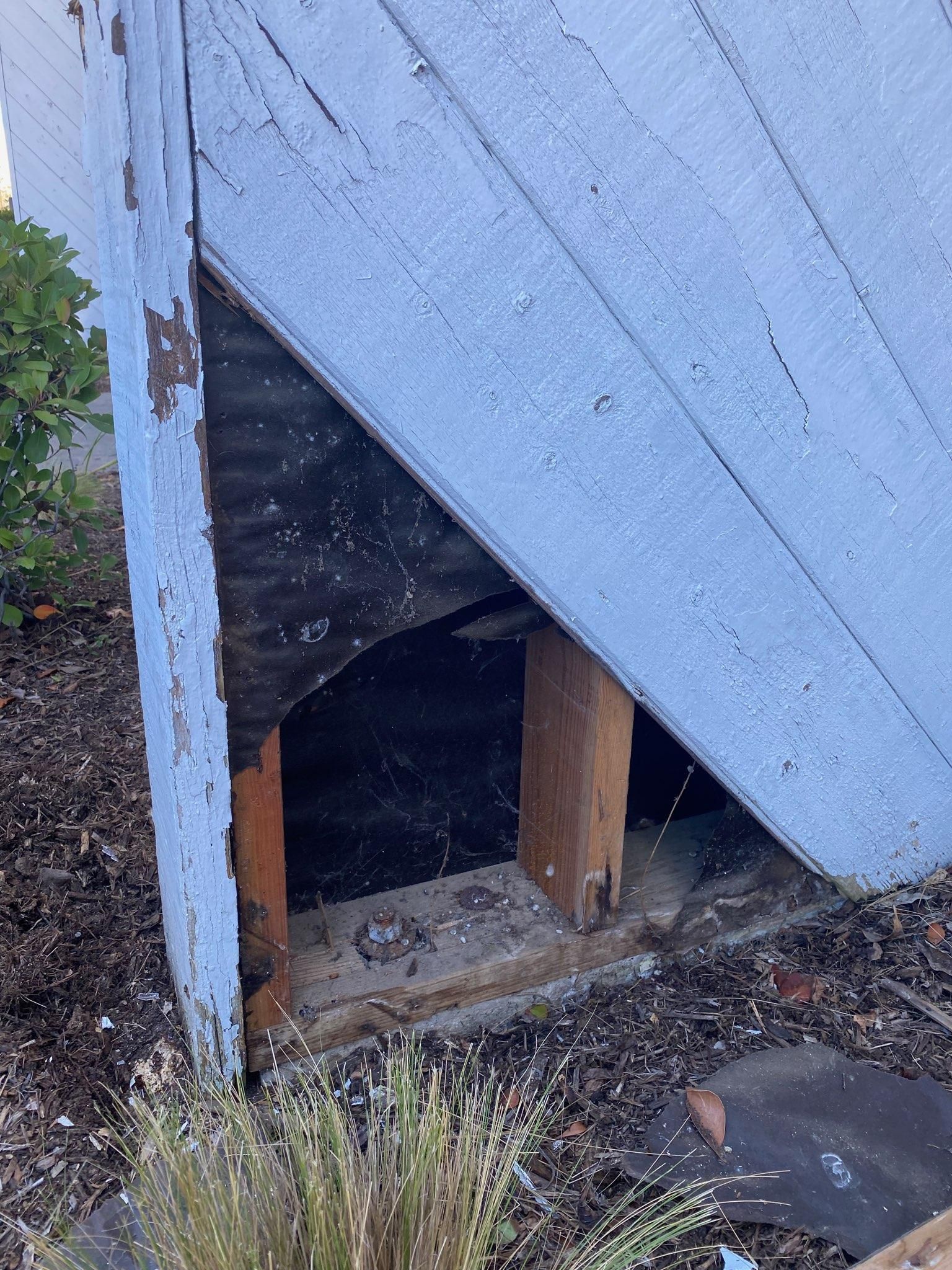 A blue building with a hole in the side of it.