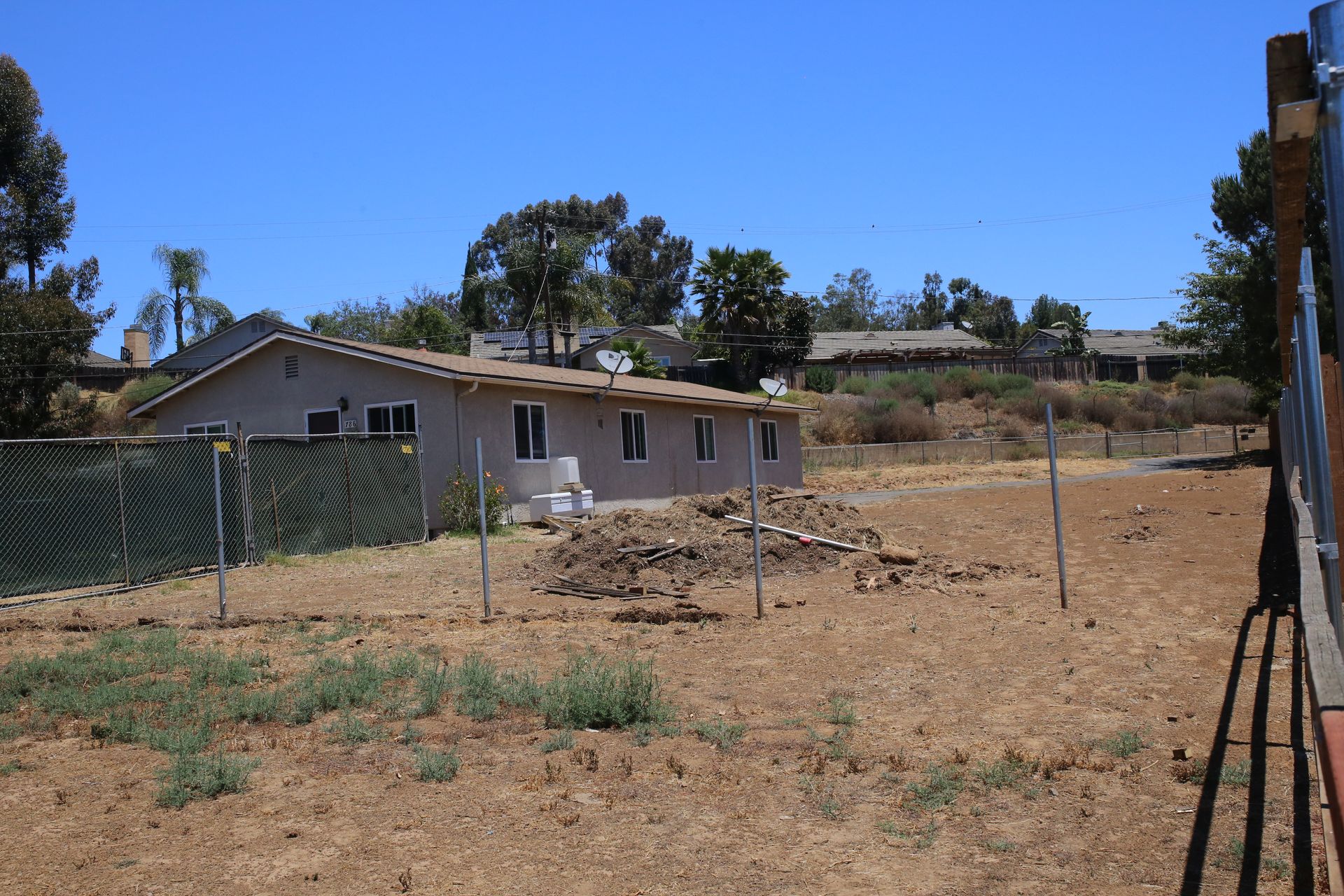 A fenced in yard with a house in the background