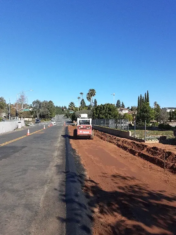A bulldozer is moving dirt on the side of a road.