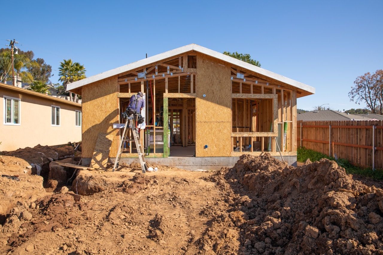 A house under construction with a pile of dirt in front of it