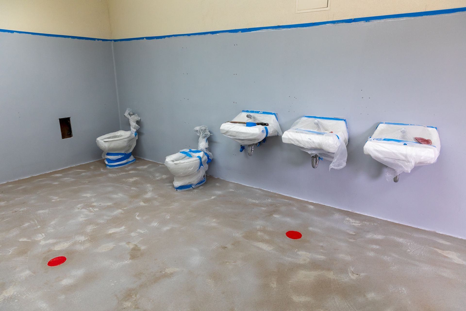 A row of toilets and sinks in a bathroom under construction.