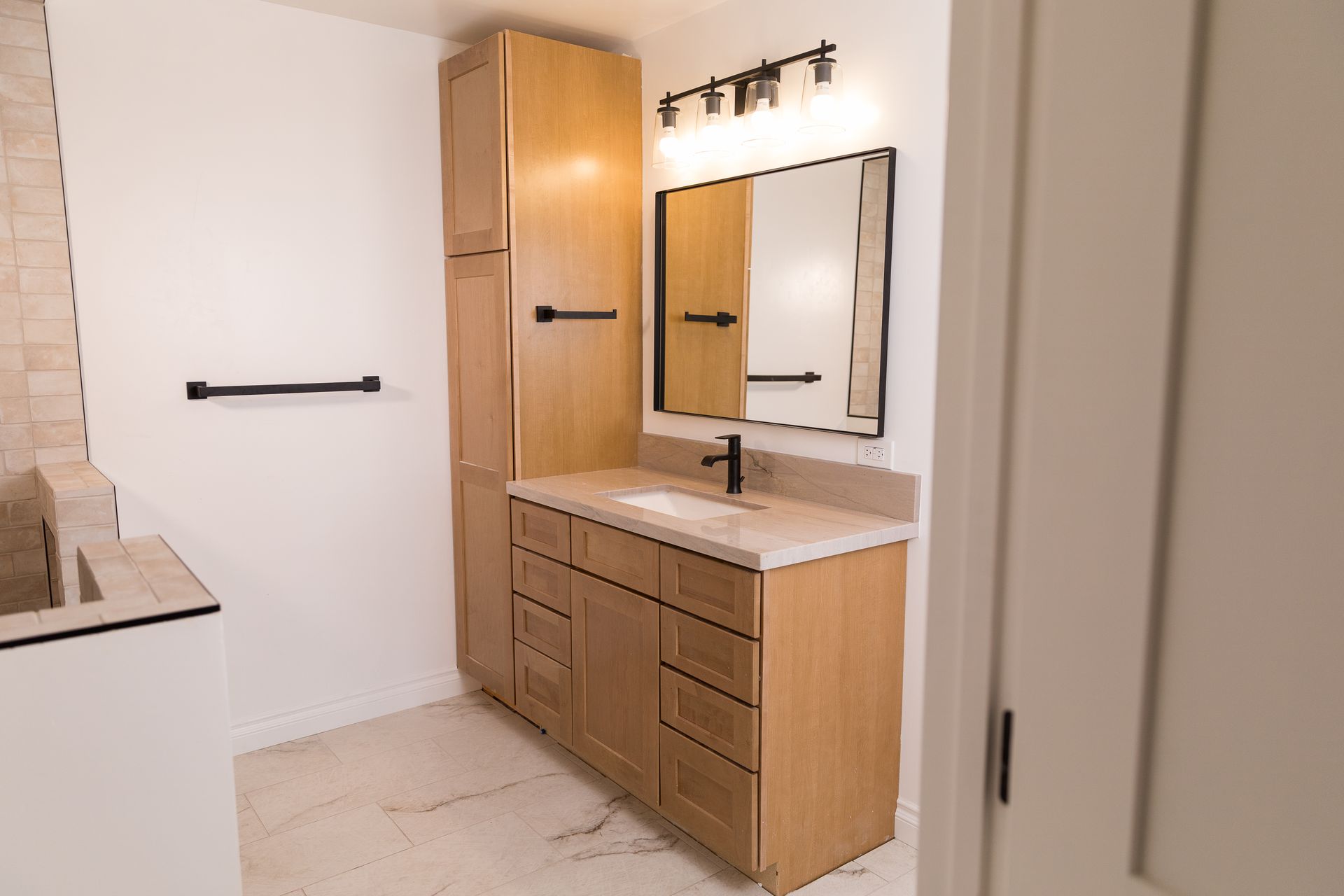 A bathroom with a sink , mirror and cabinets.